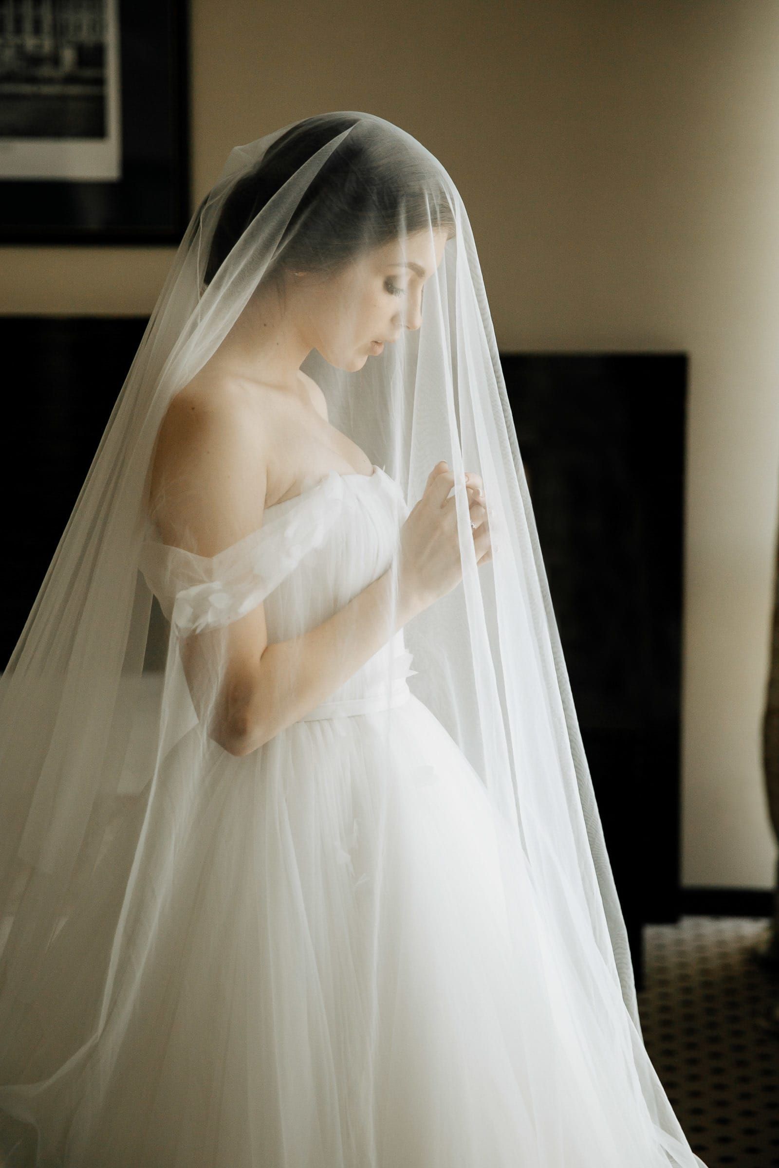 A quiet, editorial bridal portrait of the bride in her veil praying, by a Devon wedding photographer, Tanya Bogdan.