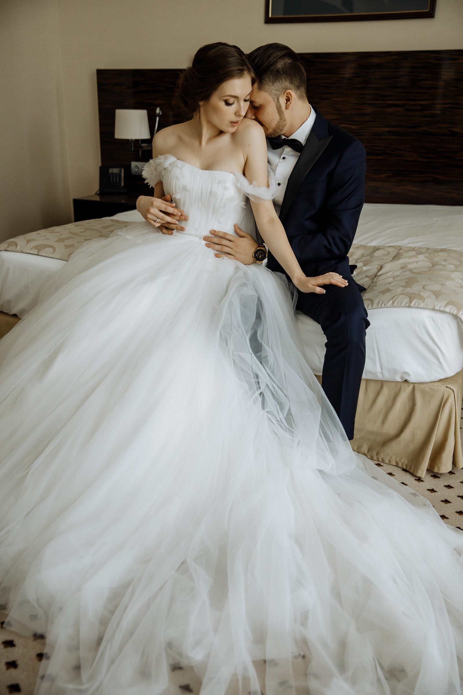 A relaxed, intimate couple portrait on a bed, by a Cornwall wedding photographer, Tanya Bogdan.