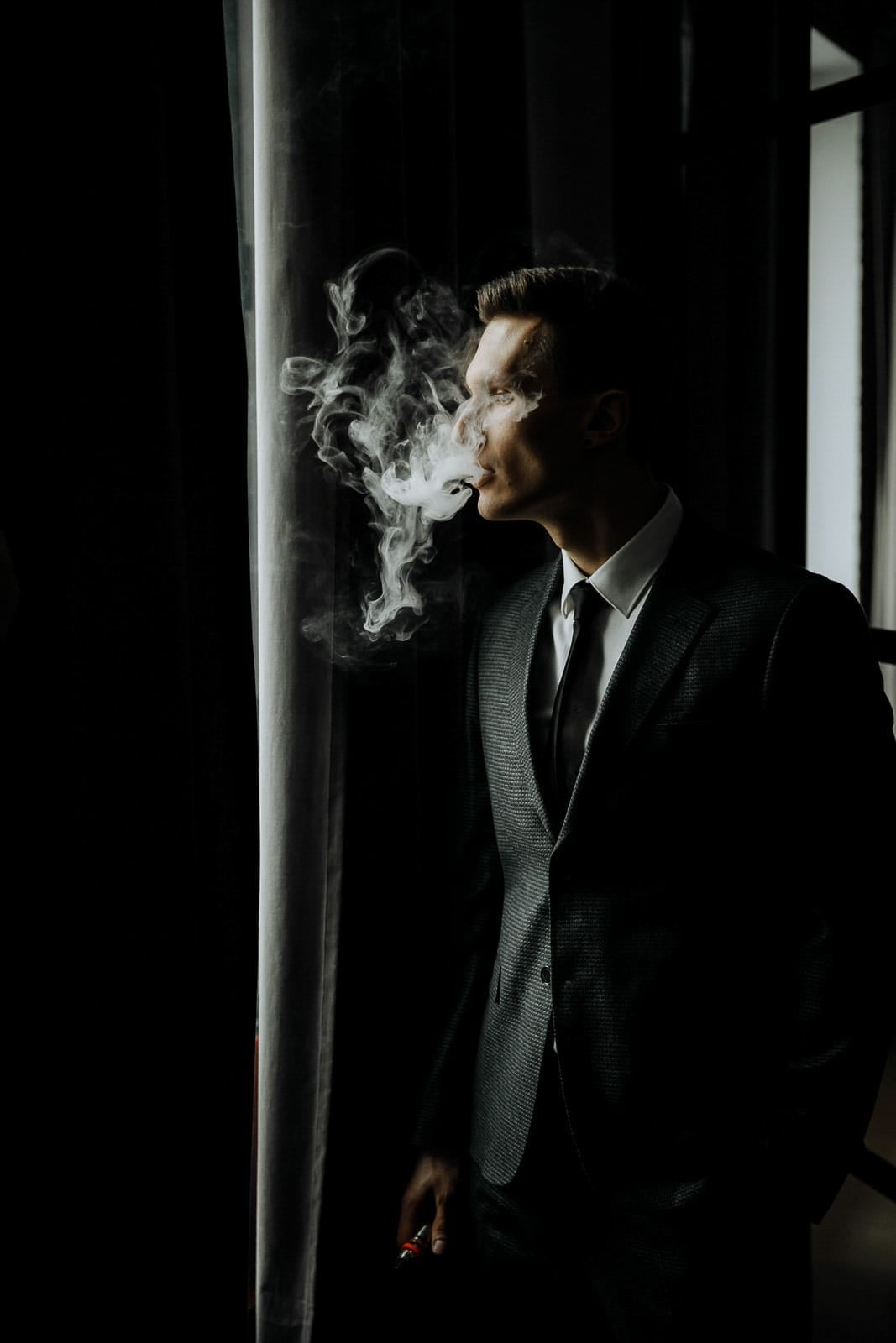 Editorial groom portrait featuring a cinematic cigar shot from Tanya Bogdan.