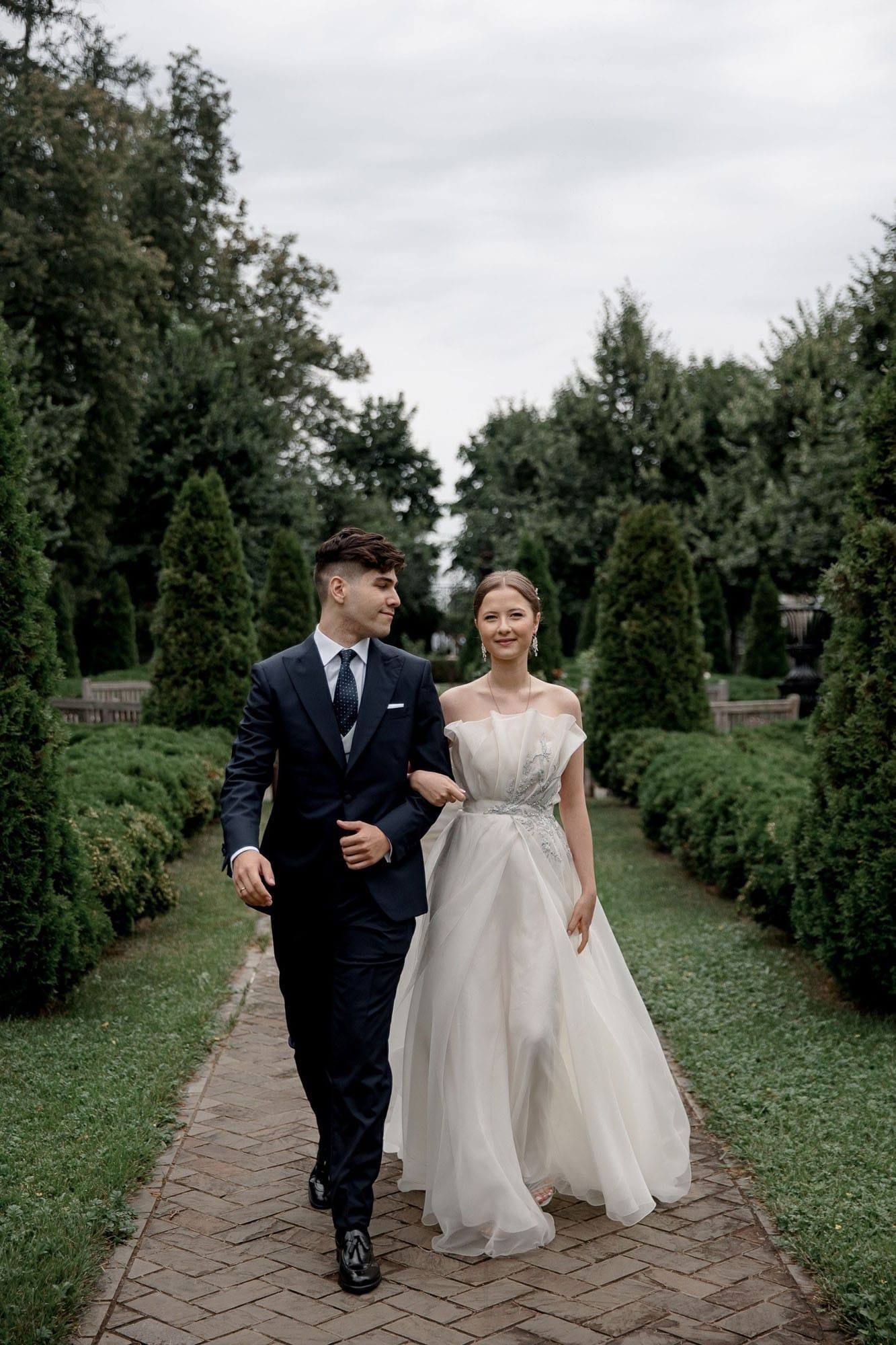 Bride and groom walking together through a garden during their destination wedding