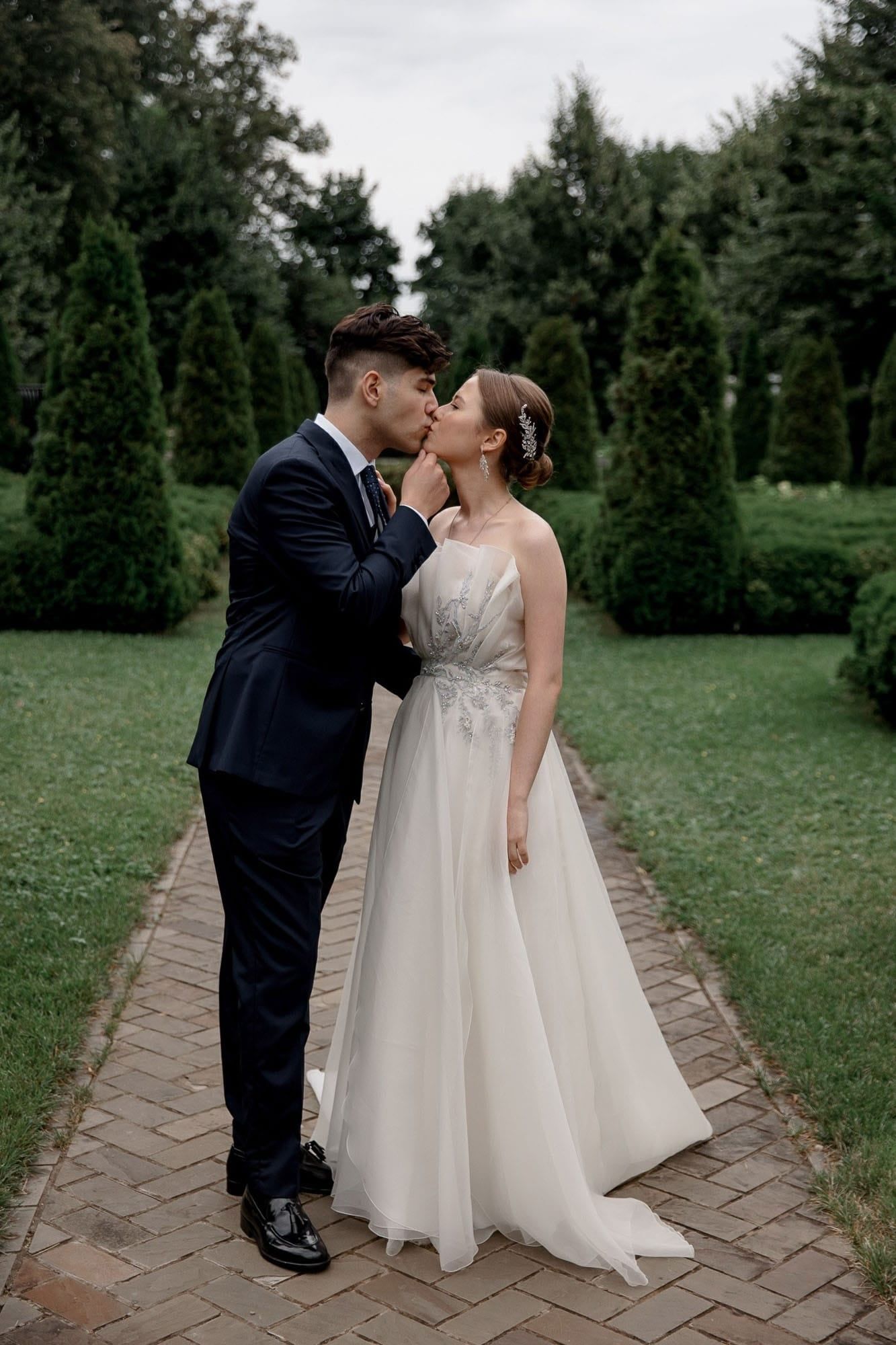 Editorial portrait of the bride and groom together in a garden during their destination wedding