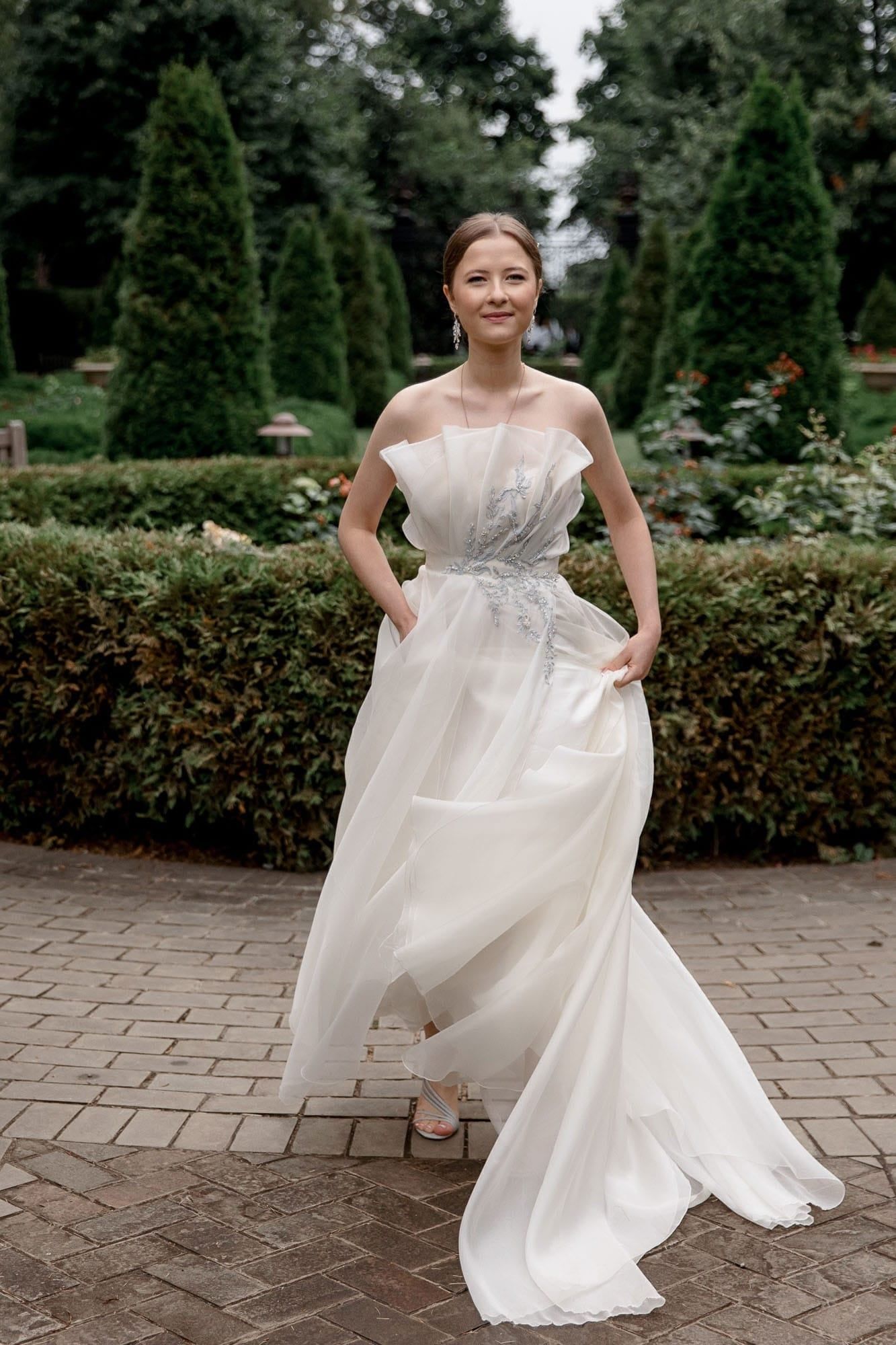 Editorial portrait of the bride standing in a garden at a destination wedding venue