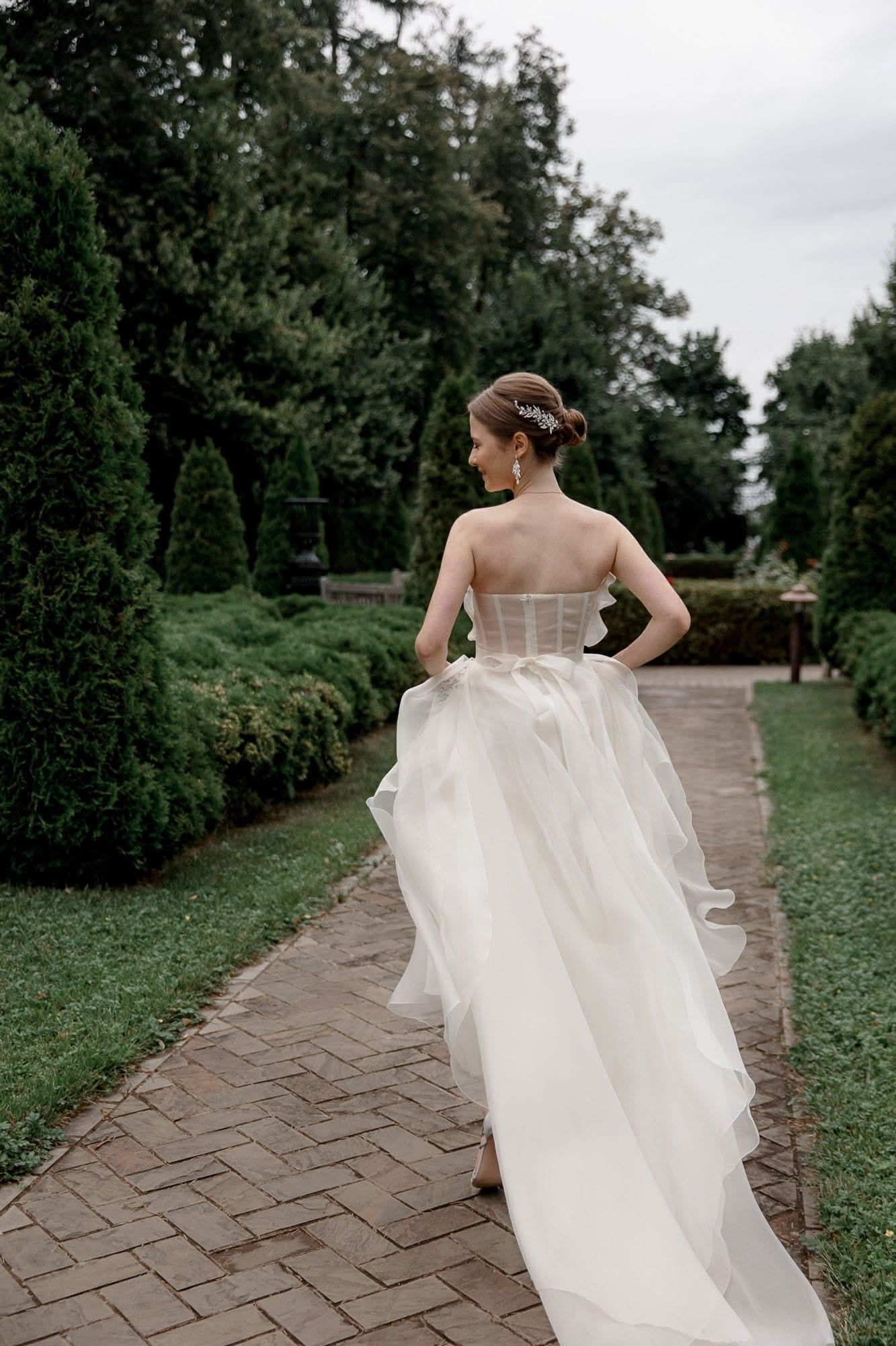 Candid moment of the bride running through a garden during her destination wedding day
