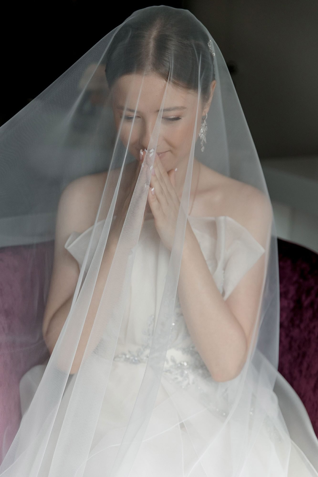 Bride in quiet prayer beneath her veil during morning preparations at a destination wedding