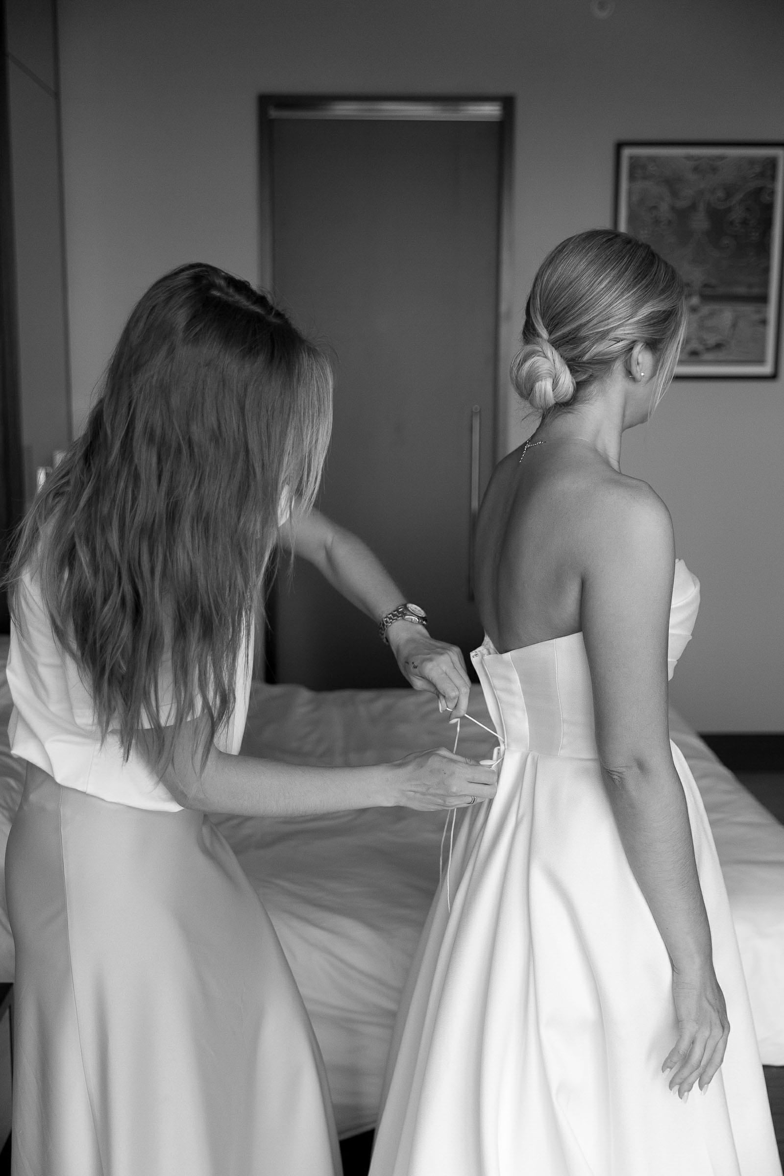 Editorial photography of a bride being helped into her dress from Devon wedding photographer Tanya Bogdan.