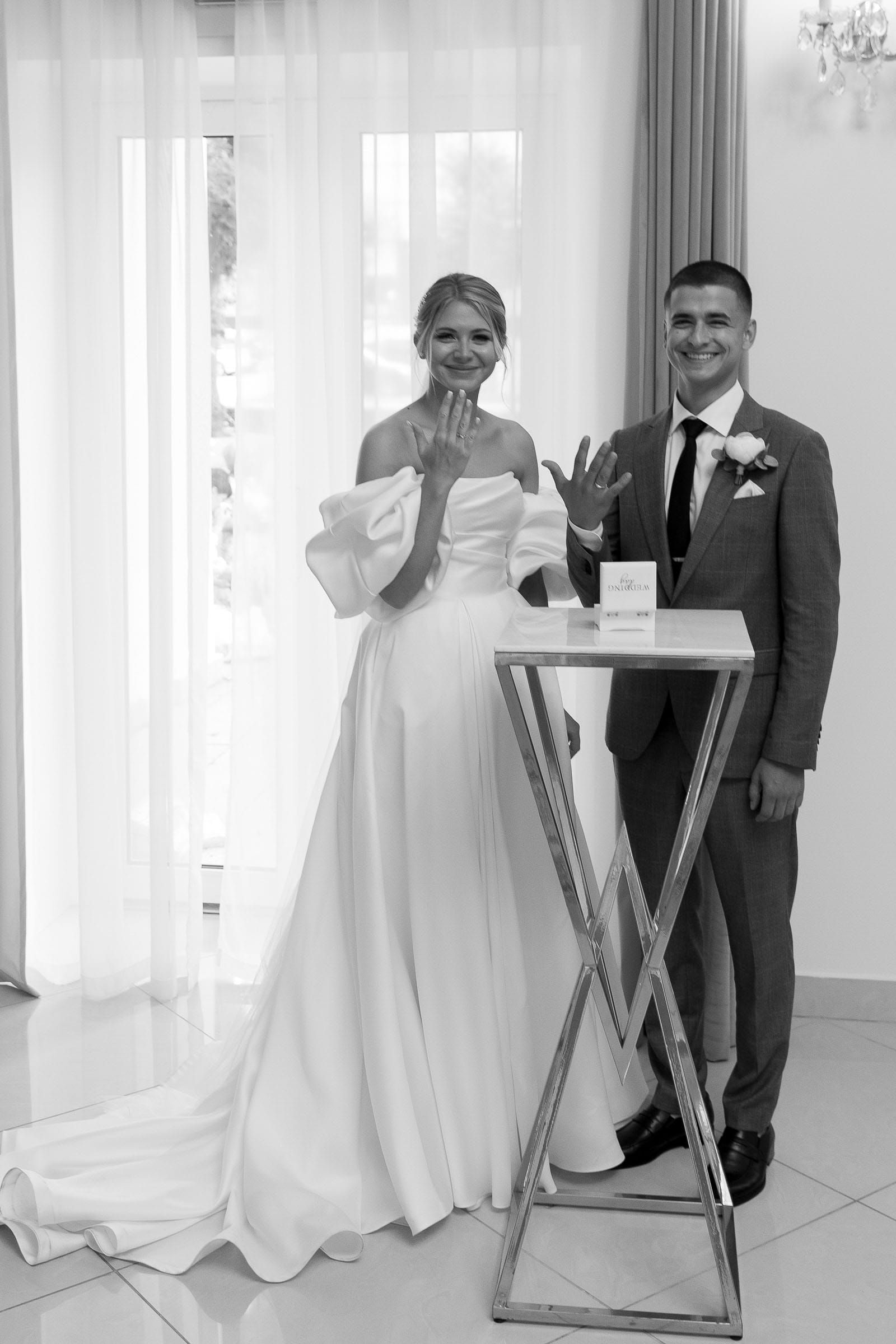 Black and white ceremony portrait of the bride and groom showing their rings by Cornwall wedding photographer Tanya Bogdan.