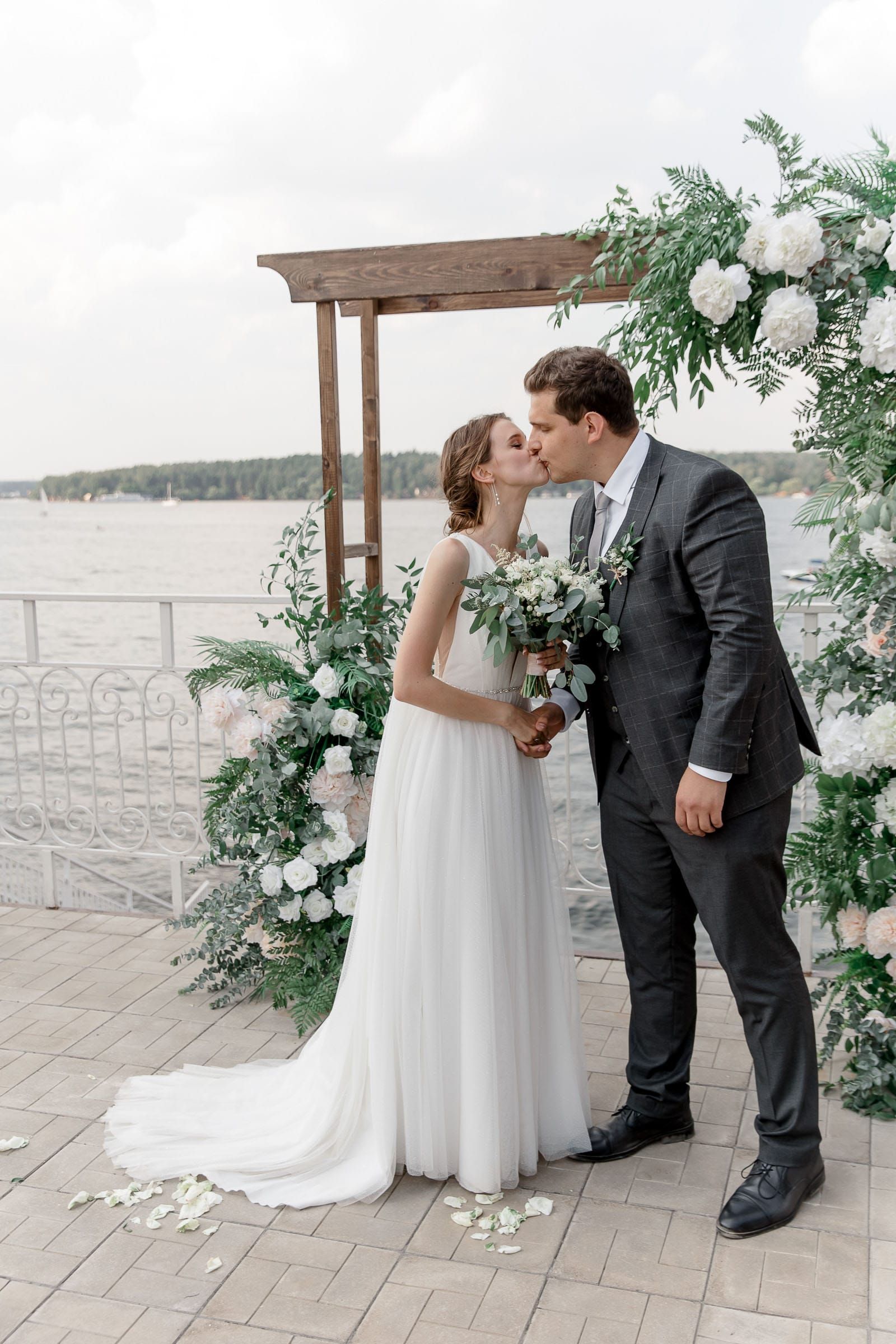 Groom kissing bride as she arrives at the altar