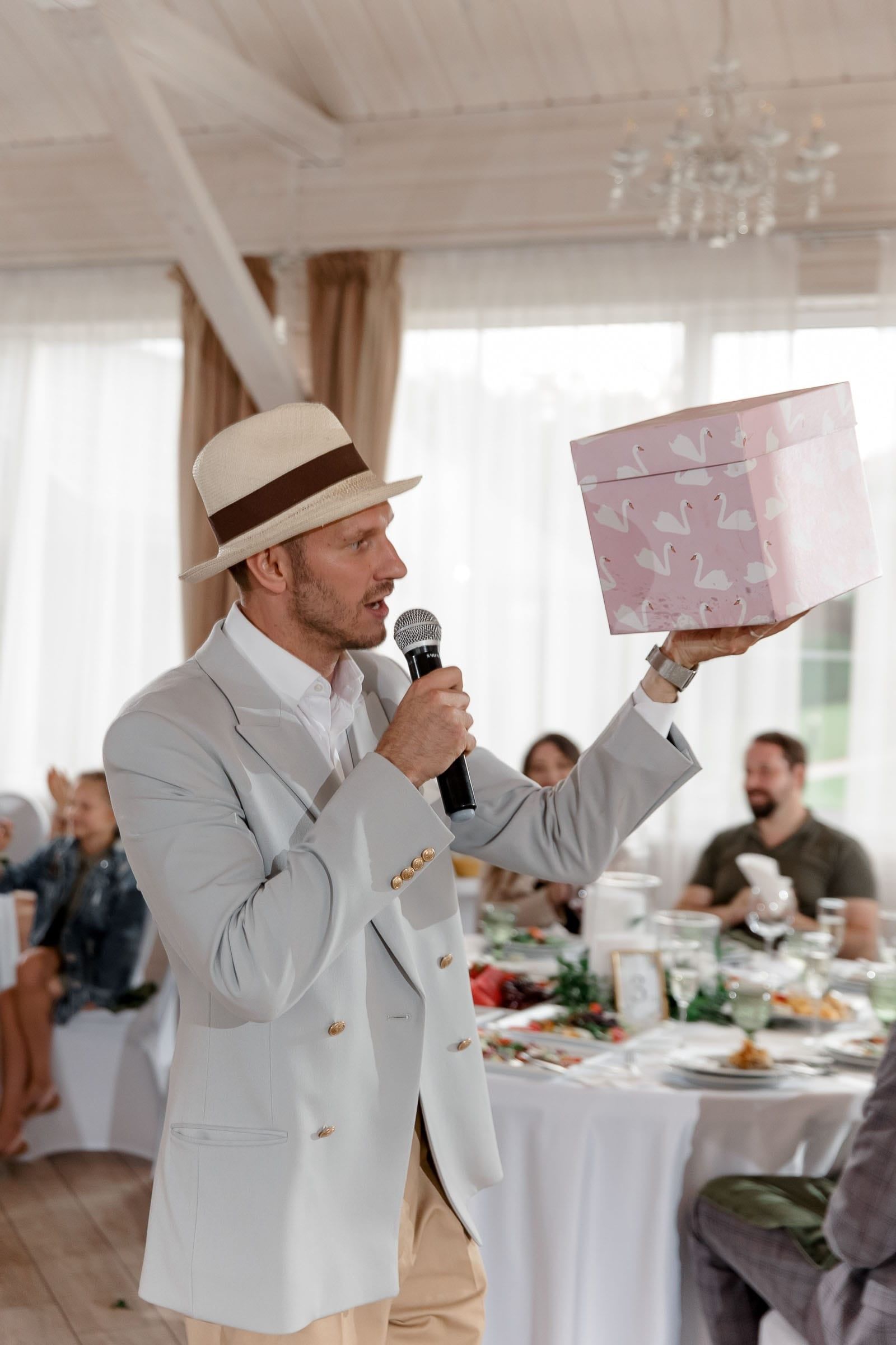 A wedding celebrant holding a present for the bride, captured by Tanya Bogdan, a Cornwall photographer.