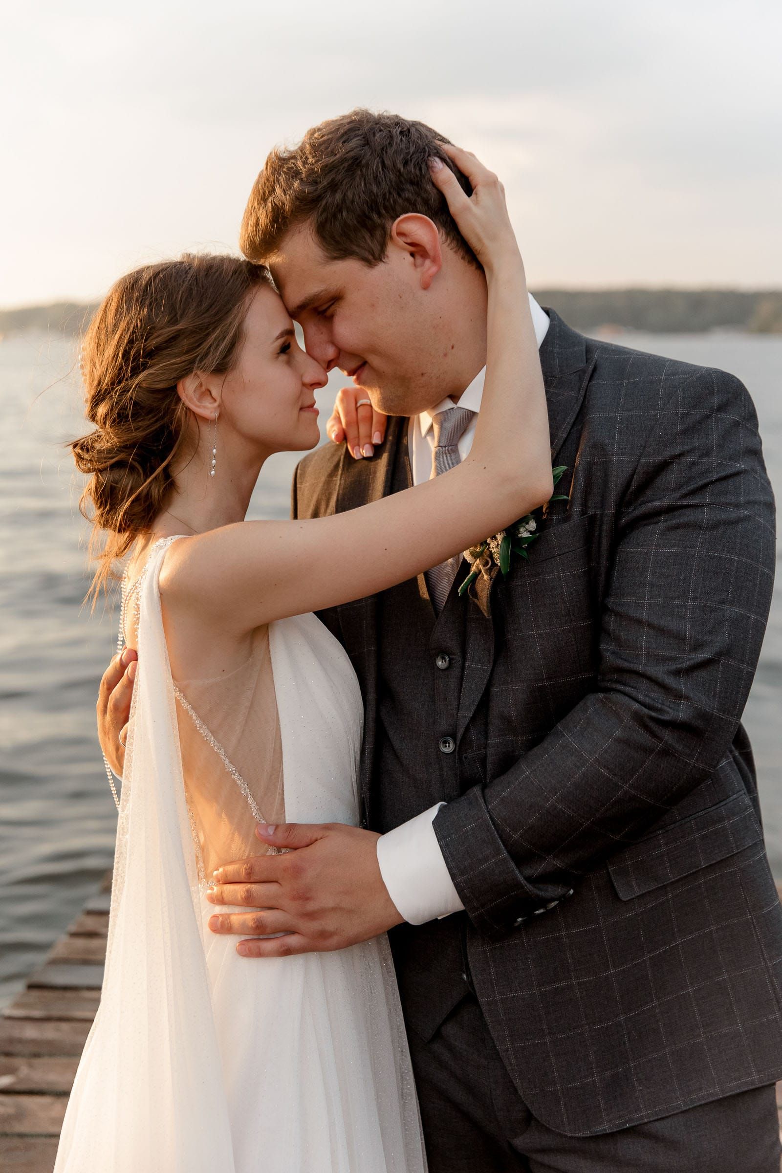 A romantic couple portrait by the river at sunset, captured by a Cornwall wedding photographer.