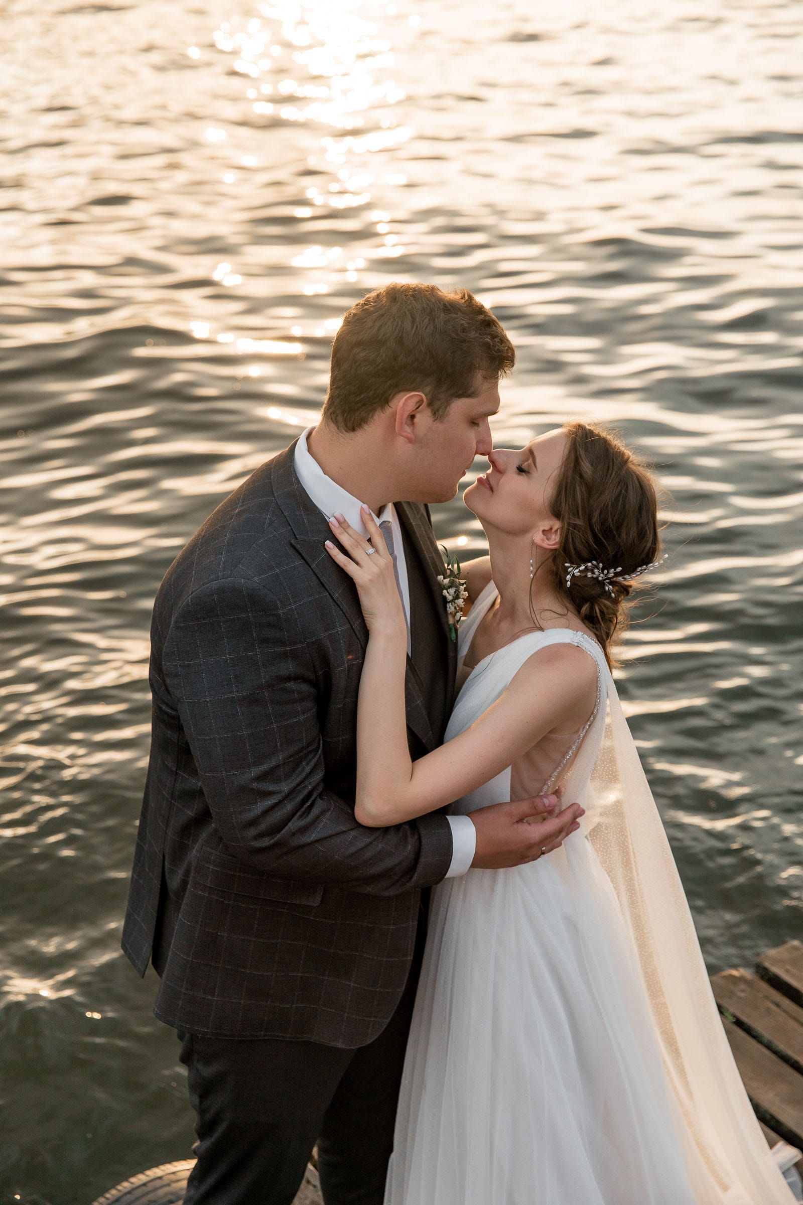 A romantic couple portrait by the river at sunset, captured by a Cornwall wedding photographer.