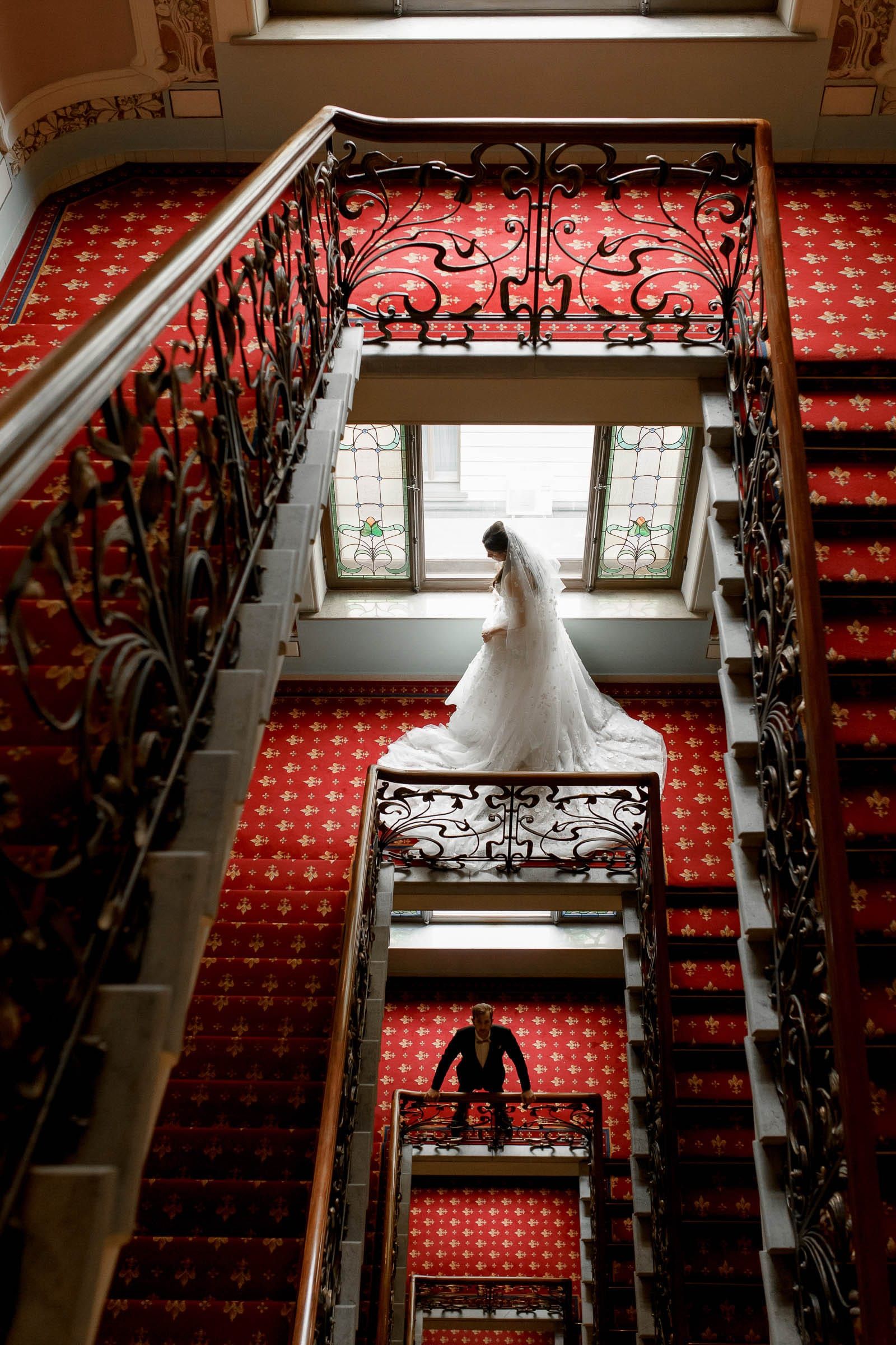 A high-fashion editorial portrait of a bride and groom on a grand staircase by Tanya Bogdan.