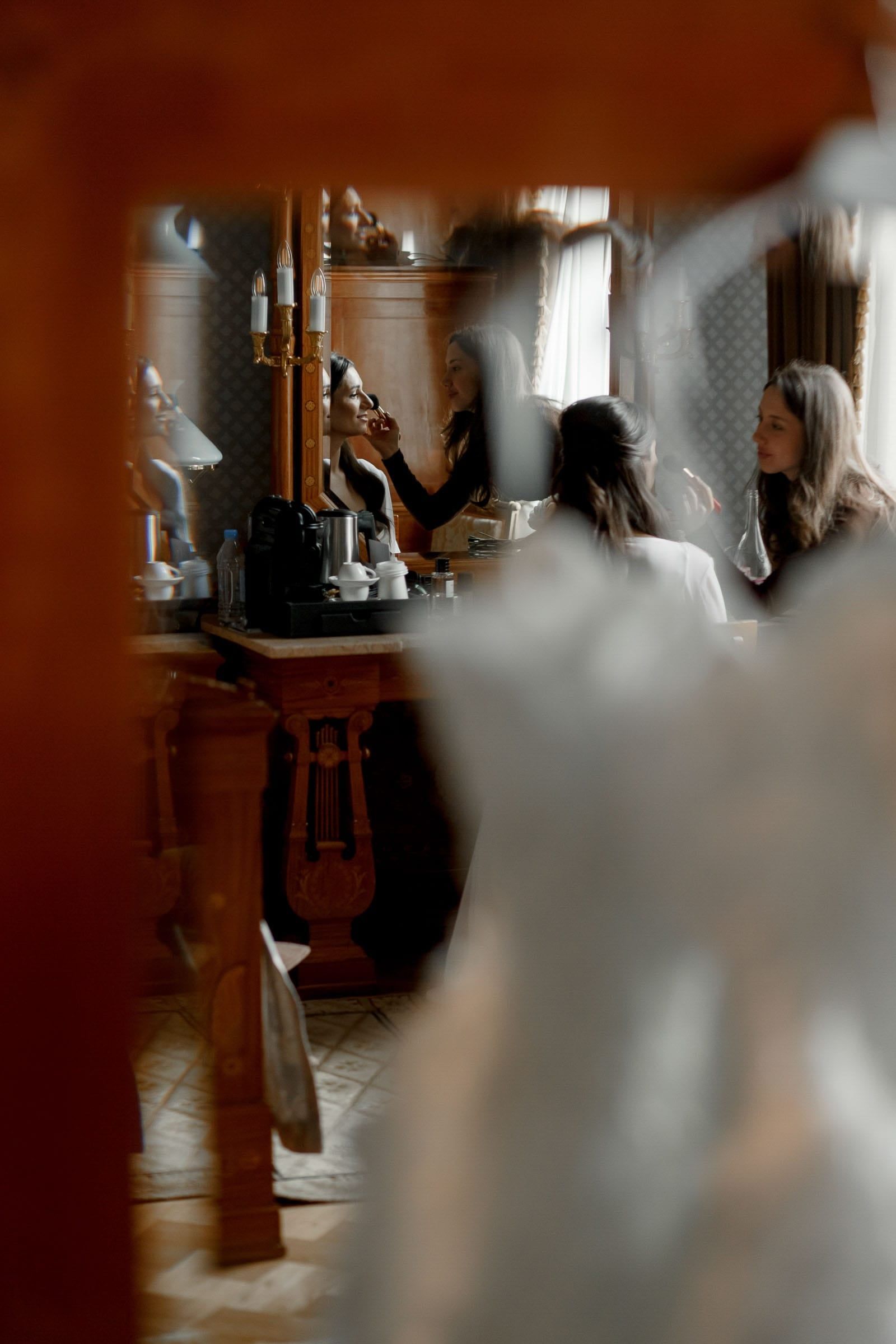 Candid photography of a bride having her makeup applied, captured by Tanya Bogdan, serving Devon and the Cotswolds.