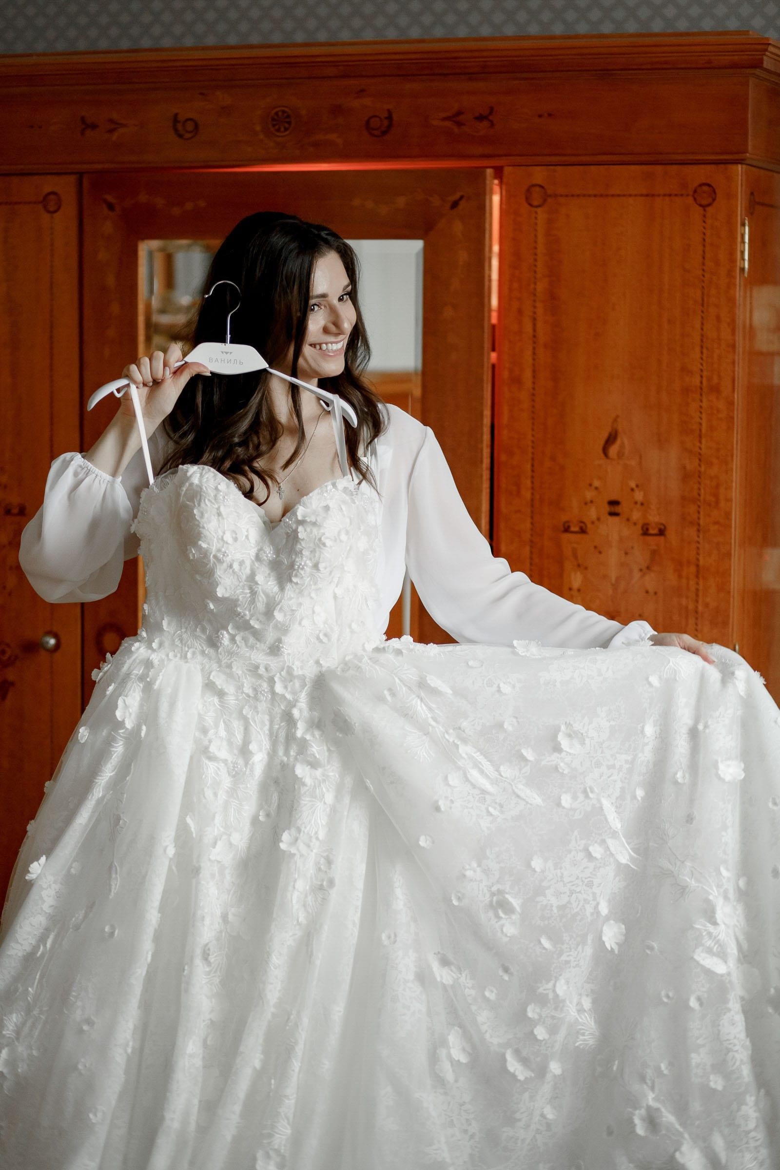 A stylish editorial shot of a bride holding her wedding dress by Tanya Bogdan, a wedding photographer serving Devon and Cornwall.