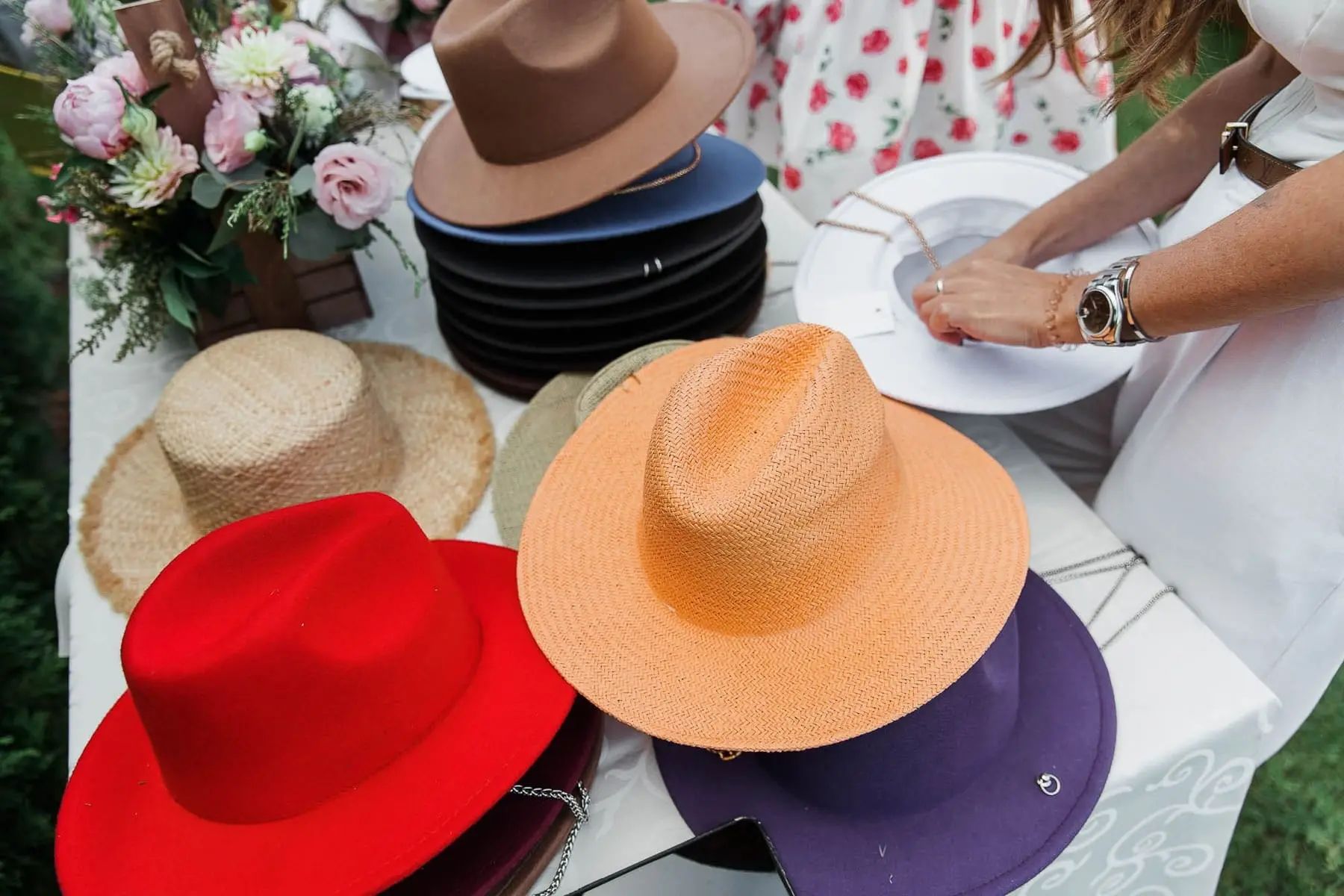 Detail shot of fashionable hats and stylish decor at a luxury garden party, by Fowey photographer Tanya Bogdan.