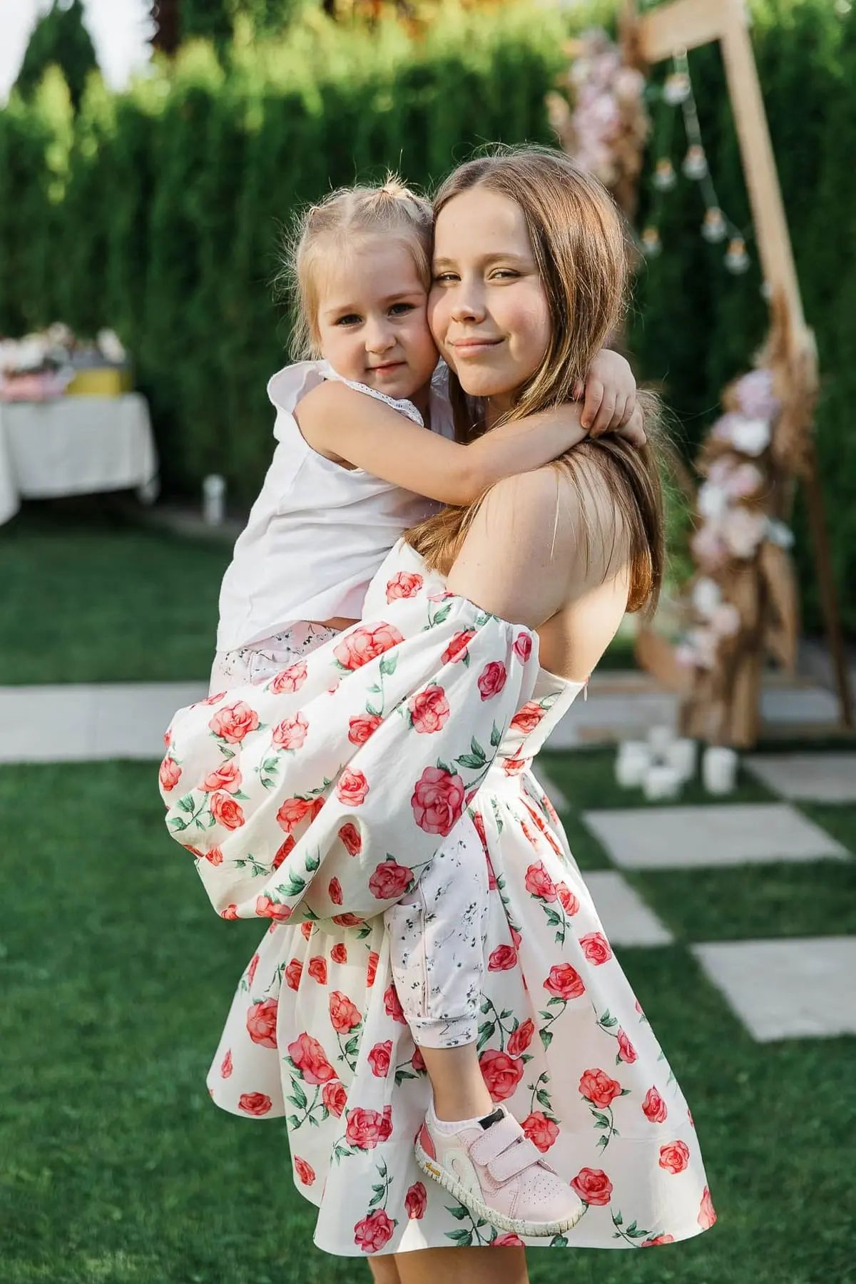 A beautiful portrait of two sisters attending a high-end garden birthday celebration, by Bude photographer Tanya Bogdan.
