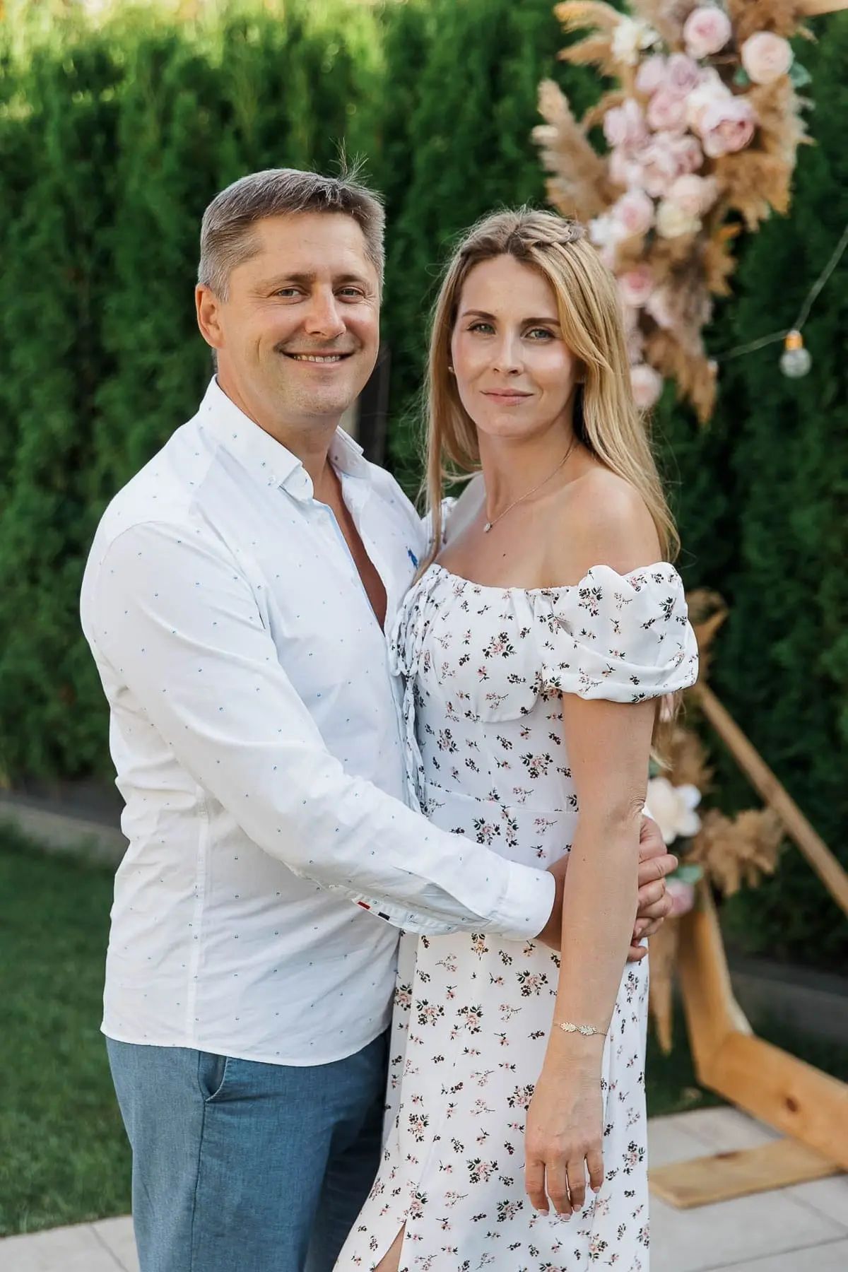 An elegant couple posing in a beautifully decorated garden during a luxury celebration, by Bude photographer Tanya Bogdan.