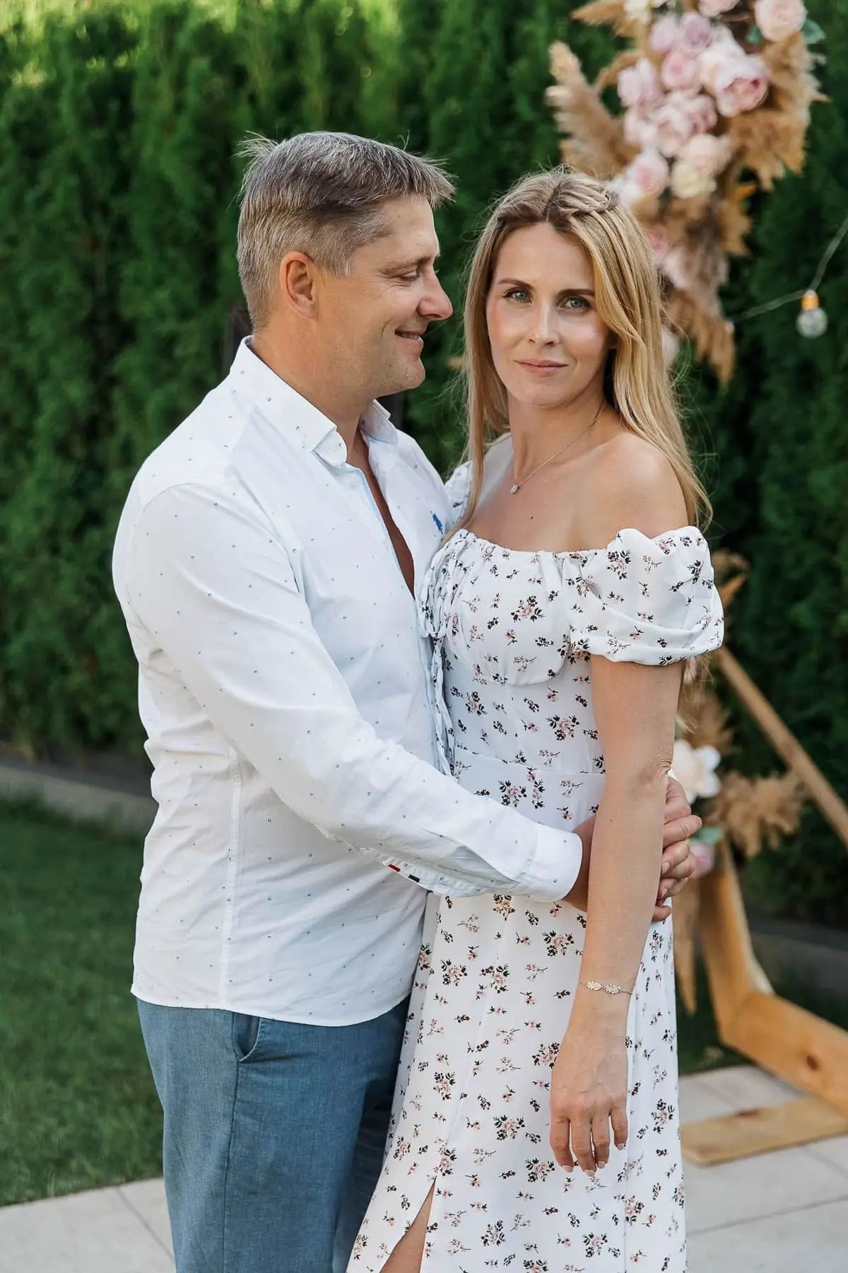 A romantic candid moment of a couple at an outdoor high-end birthday party, by Bude photographer Tanya Bogdan.