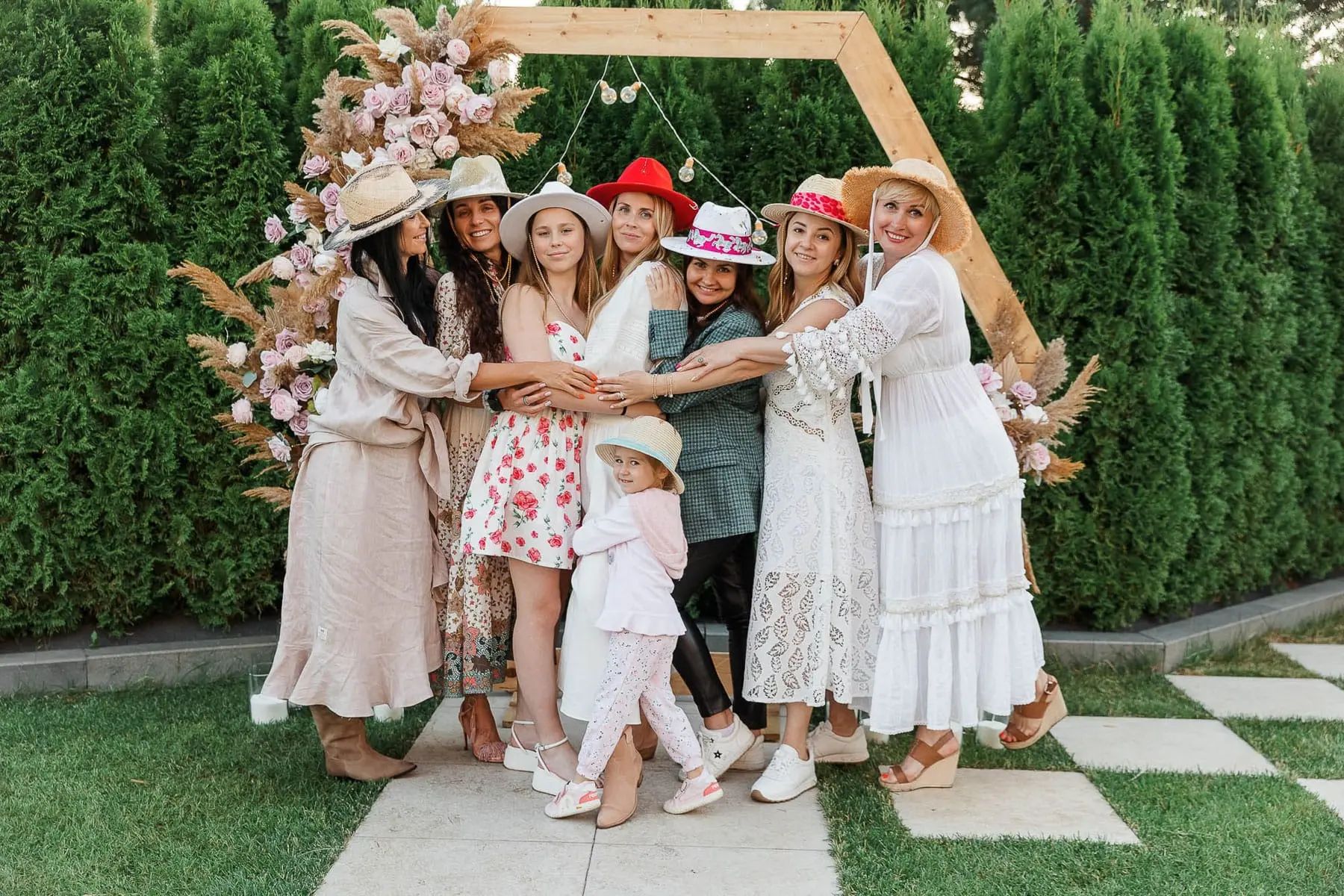 A professional group shot of guests standing in front of an elegant floral installation, by Bude photographer Tanya Bogdan.