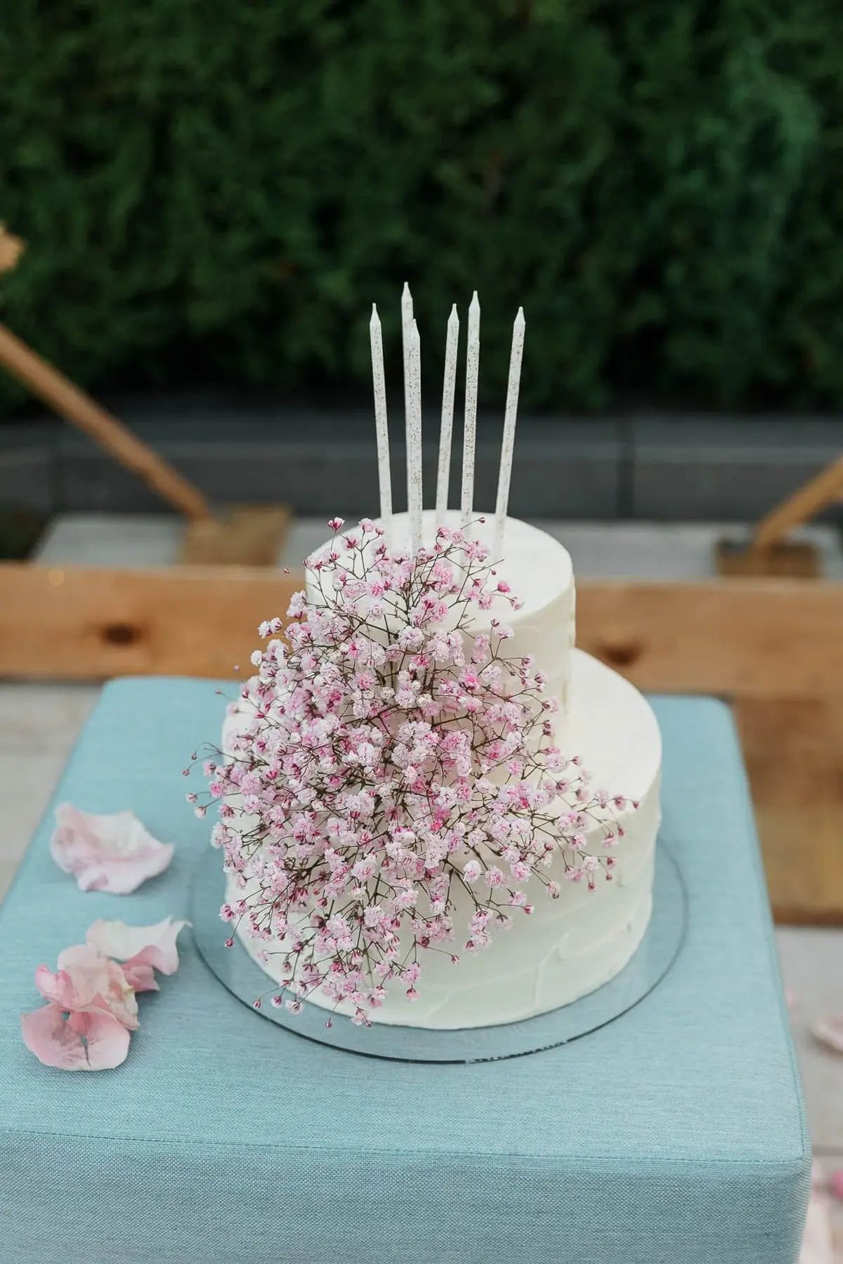 A close-up shot of a gourmet tiered birthday cake at a luxury garden party, captured by Bude photographer Tanya Bogdan.