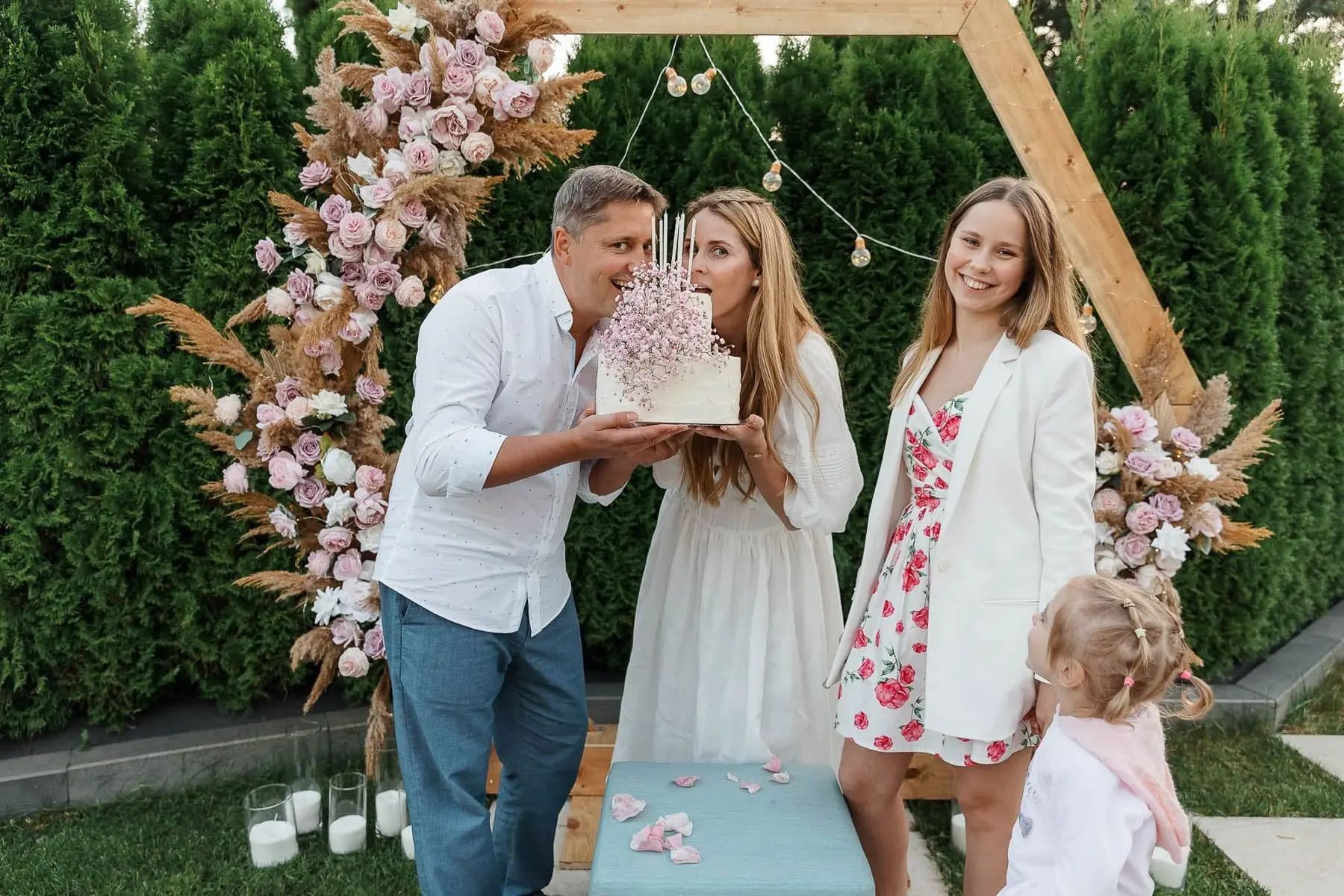A joyful family group shot gathered around a birthday cake during a bespoke celebration, by Bude photographer Tanya Bogdan.