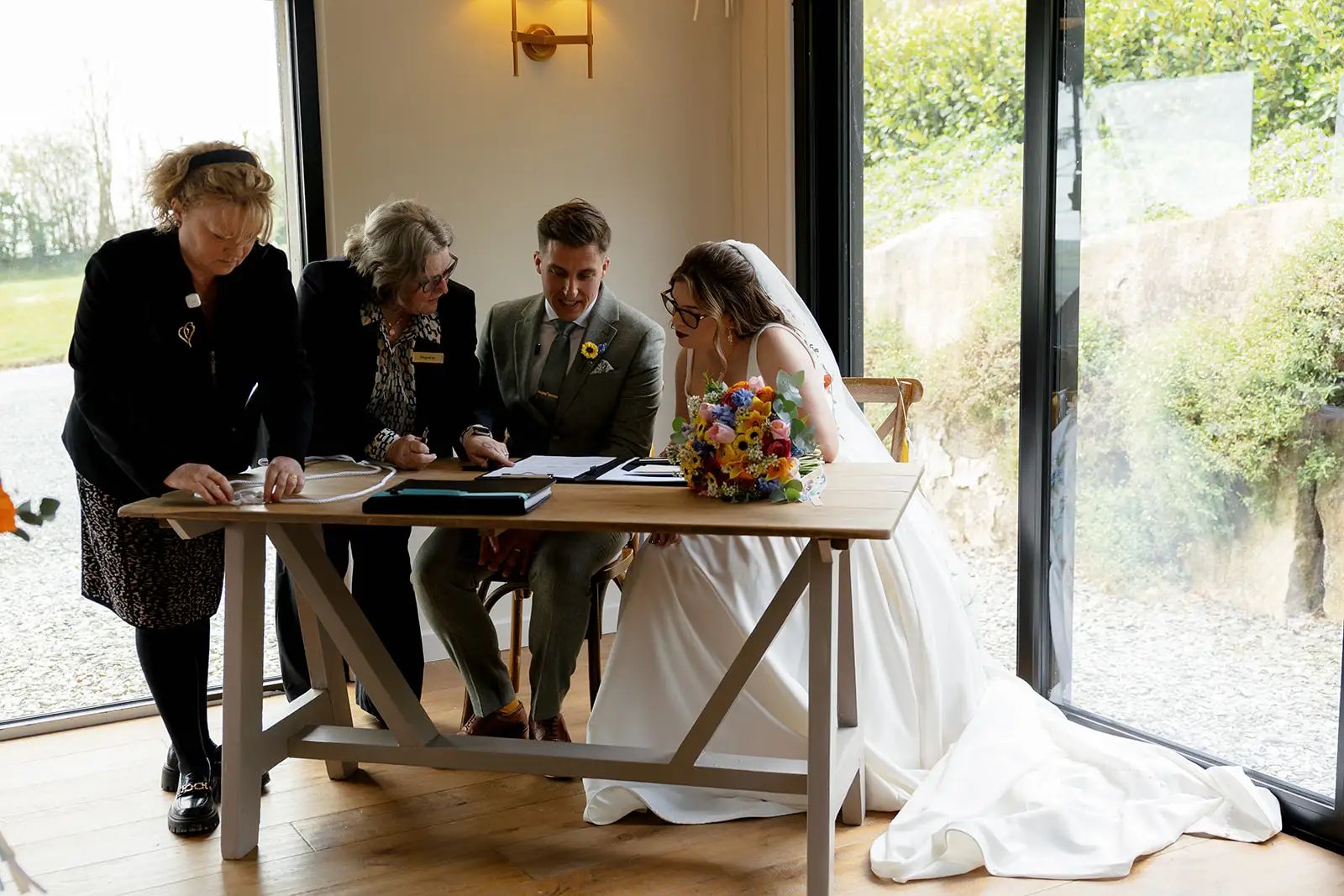 Bride and groom signing the register during their Trevenna wedding