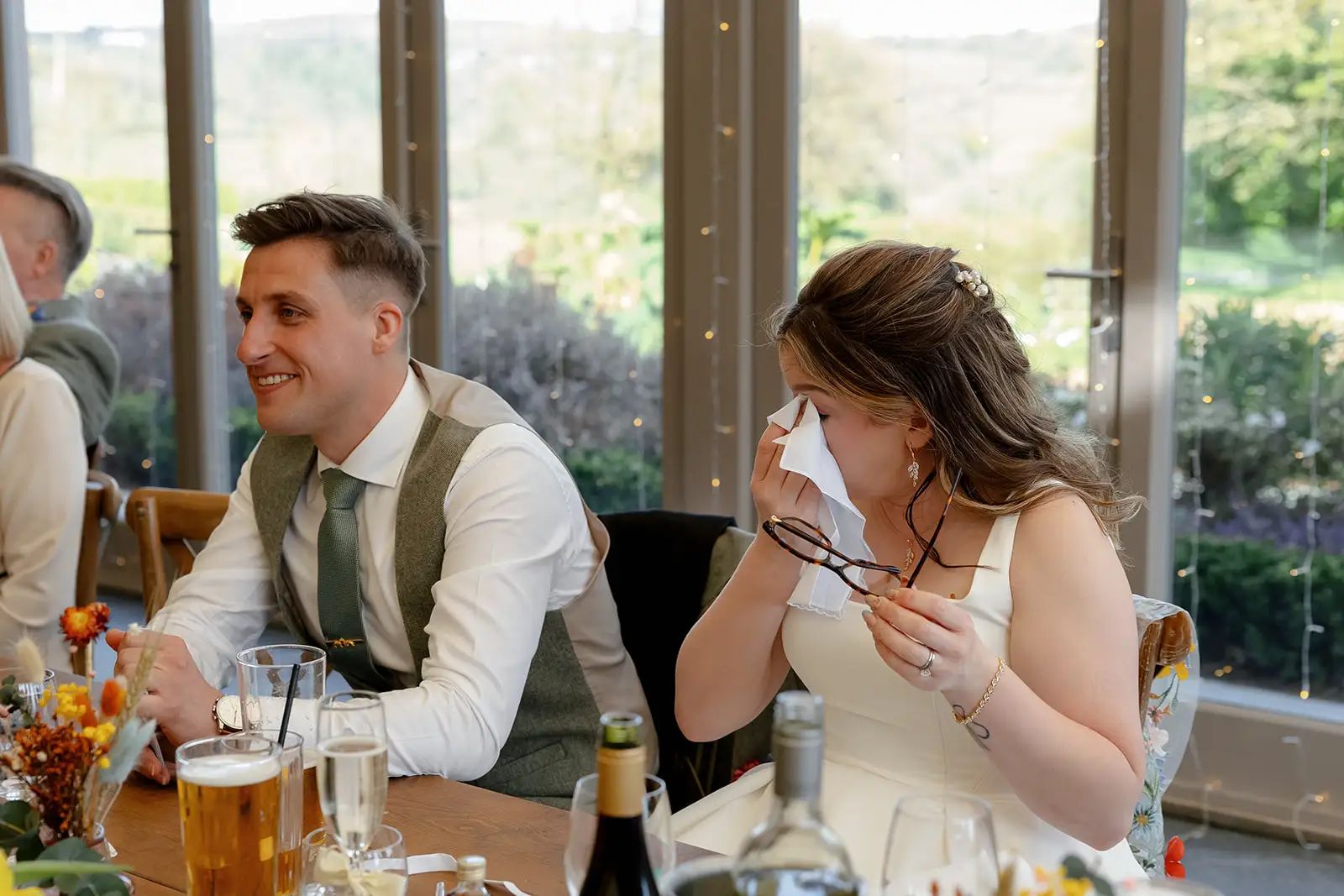 Bride and groom photographed together during their Trevenna wedding as bride wipes tears