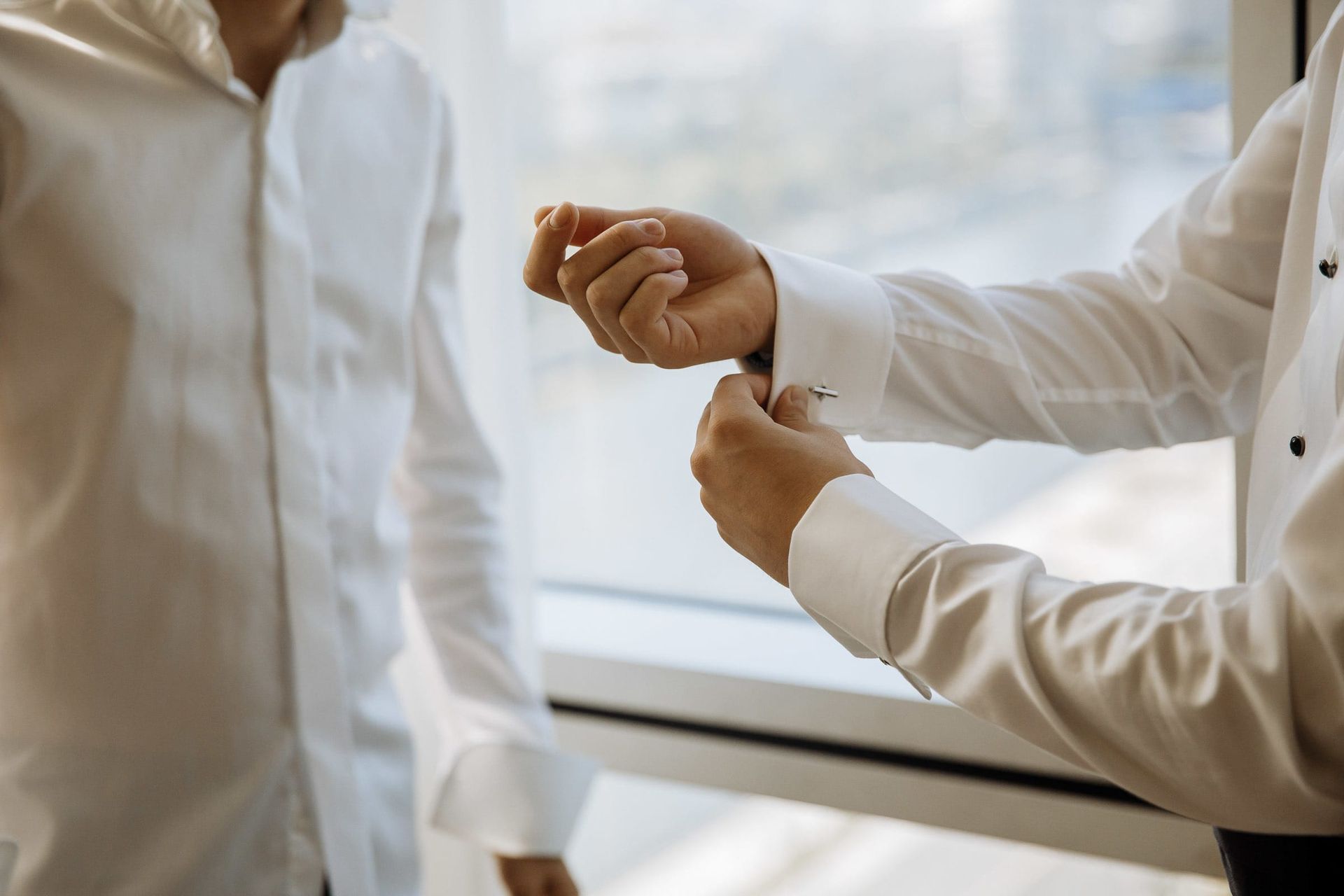 Close-up detail of a groom adjusting his cufflinks, by a South West wedding photographer, Tanya Bogdan.