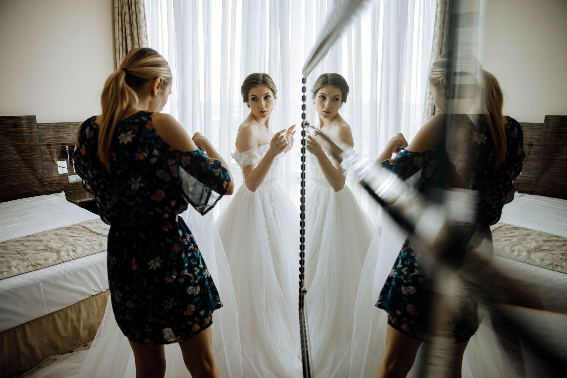 A creative mirror reflection of the bride and her sister during morning prep.