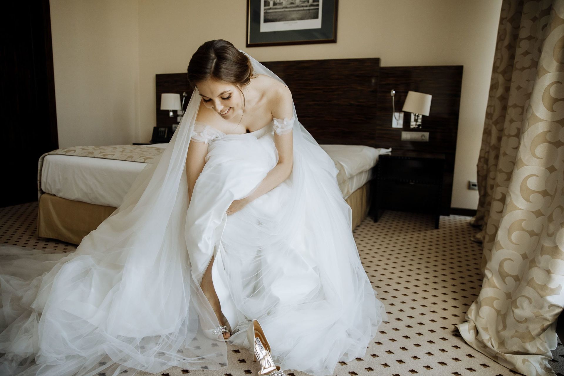 Candid shot of the bride putting on her wedding heels during morning prep.