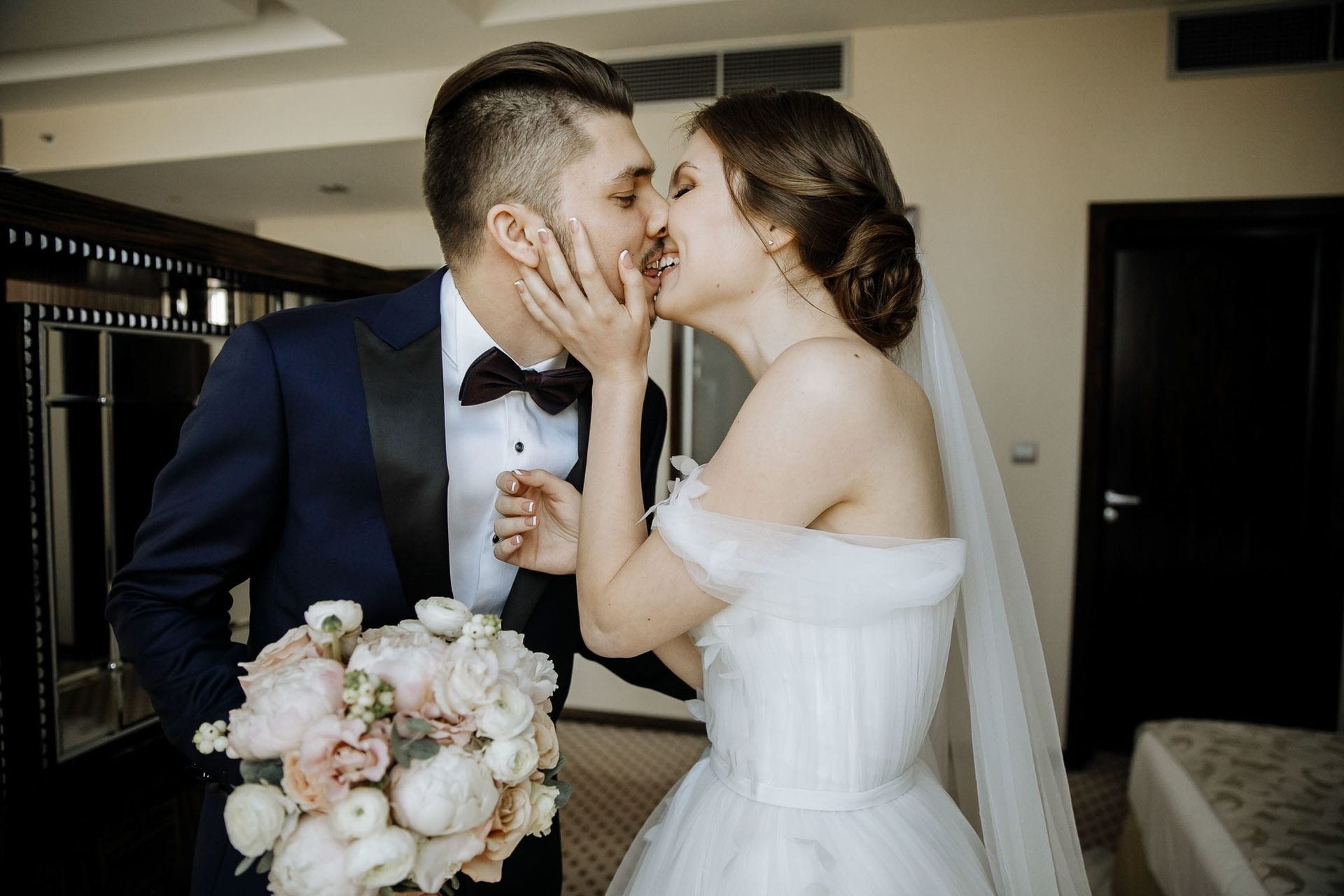 A romantic kiss shared during a first look session, by a wedding photographer, Tanya Bogdan.