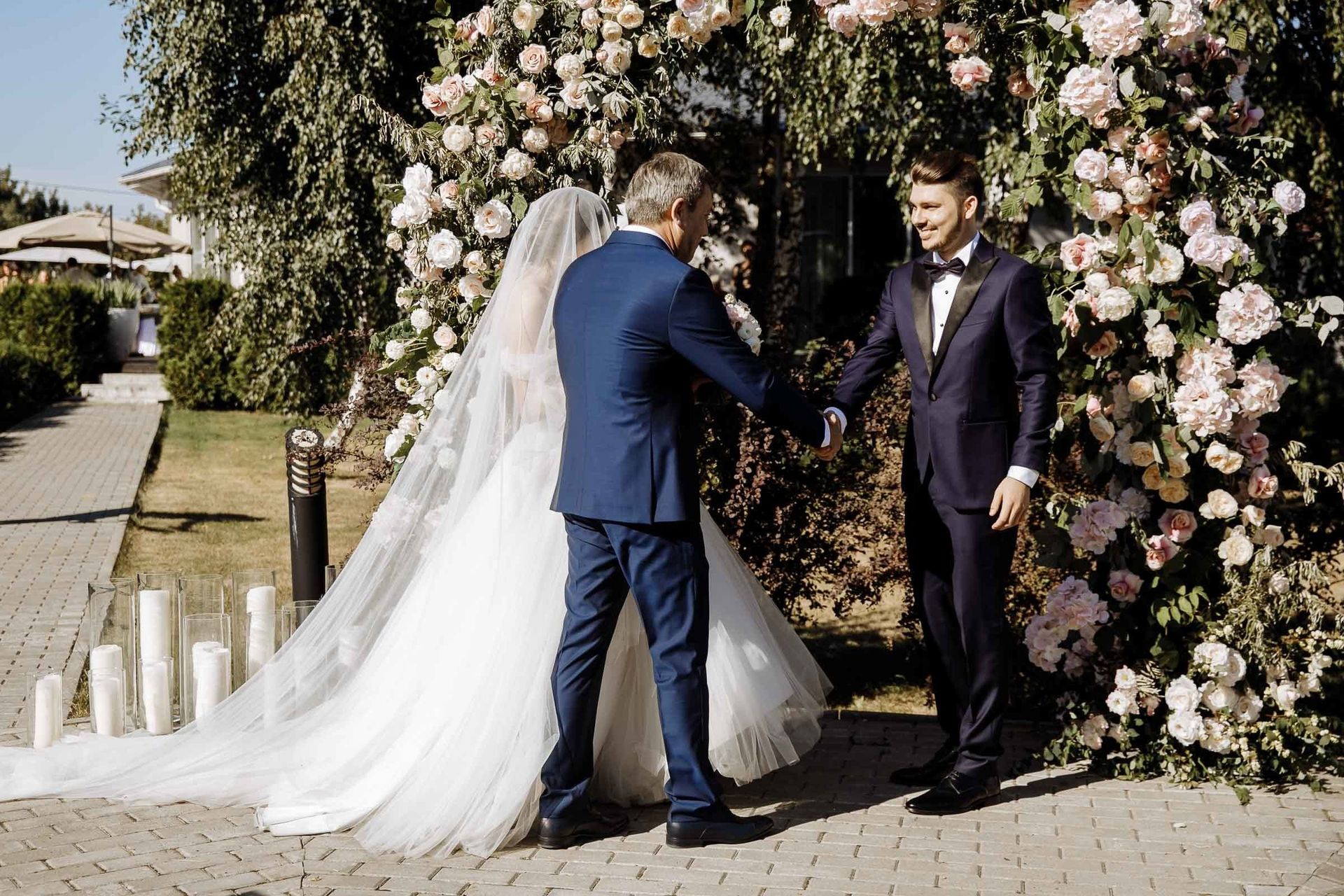 Father of the bride shaking hands with the groom at the altar, by a Cornwall wedding photographer, Tanya Bogdan.
