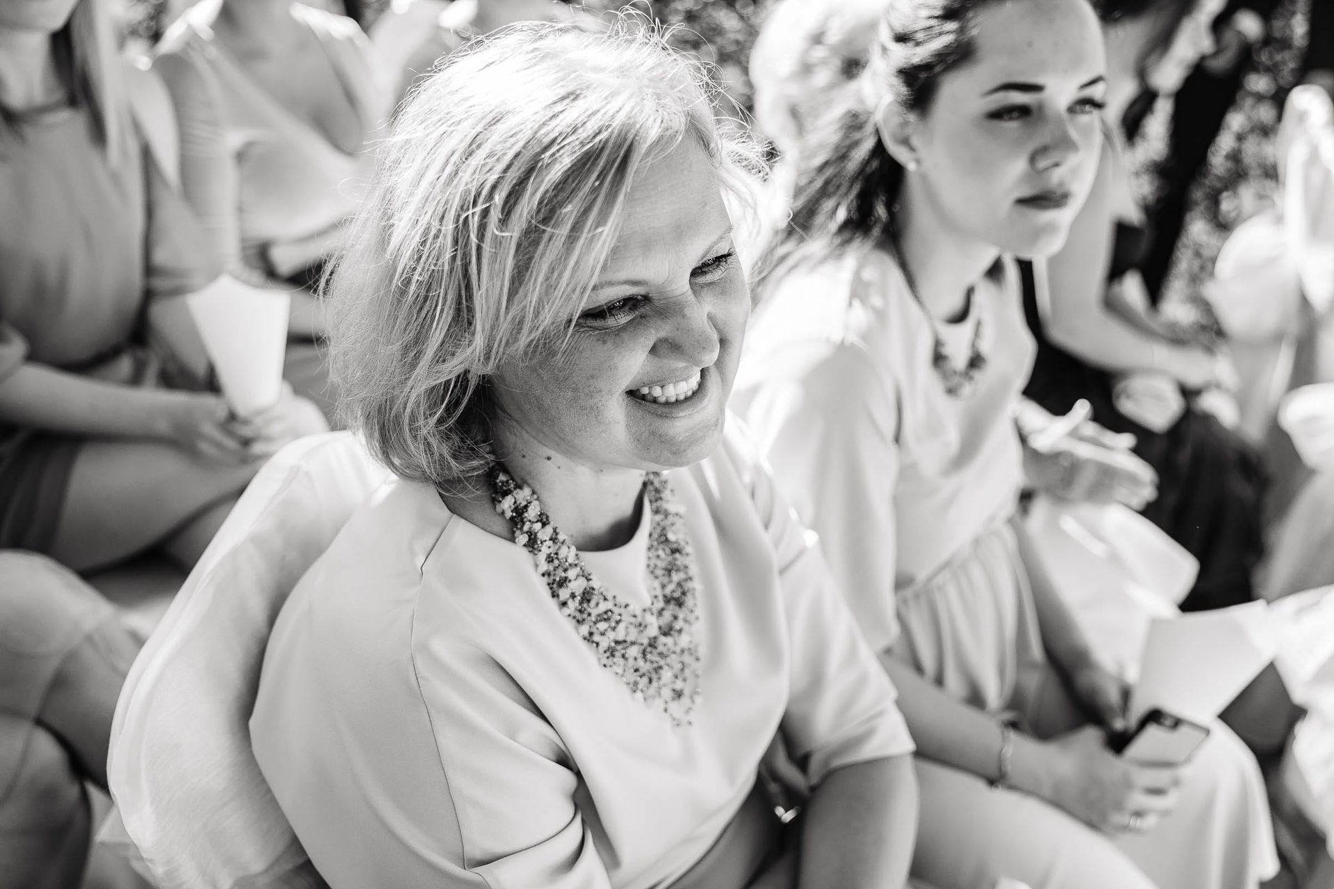 Candid guest reactions and smiles during a wedding ceremony, by a Cornwall wedding photographer, Tanya Bogdan.