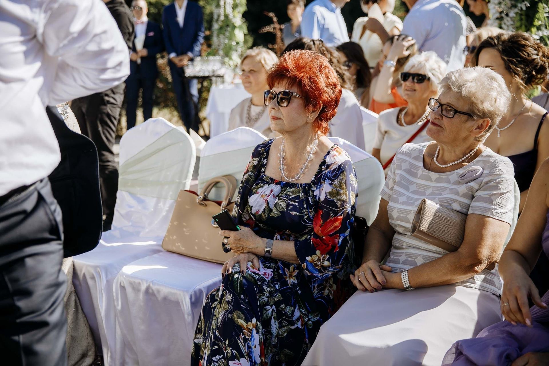 Documentary-style shot of guests smiling at an outdoor wedding, by a Cornwall wedding photographer, Tanya Bogdan.