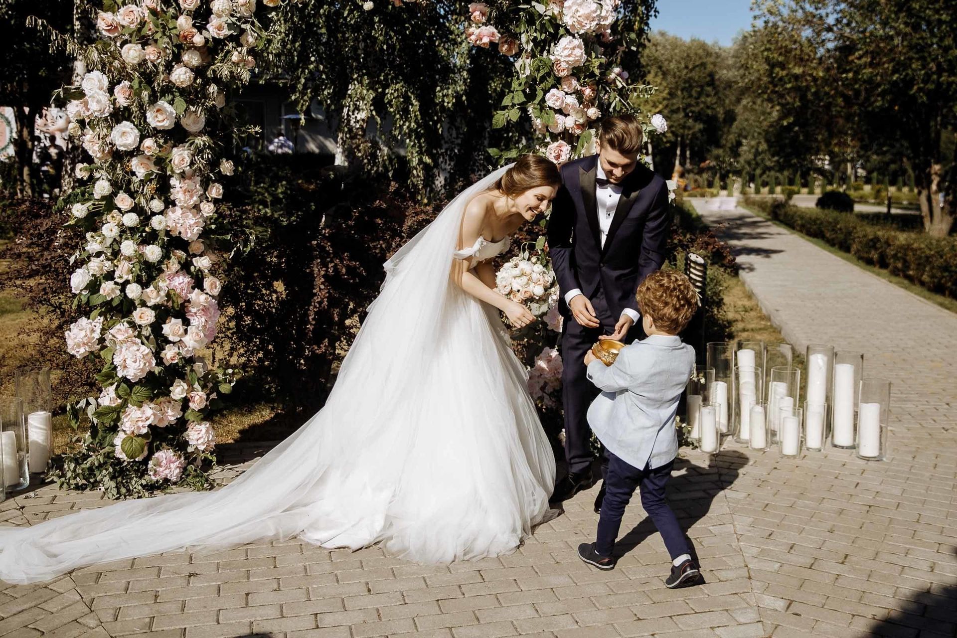 A sweet moment of a ring bearer with the bride and groom, by a Cornwall wedding photographer, Tanya Bogdan.