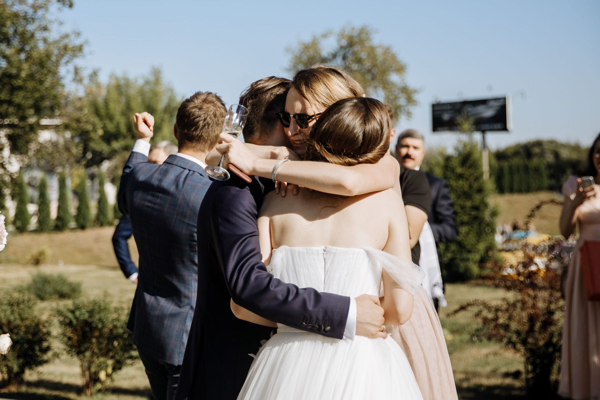 The bride and groom being congratulated by wedding guests.