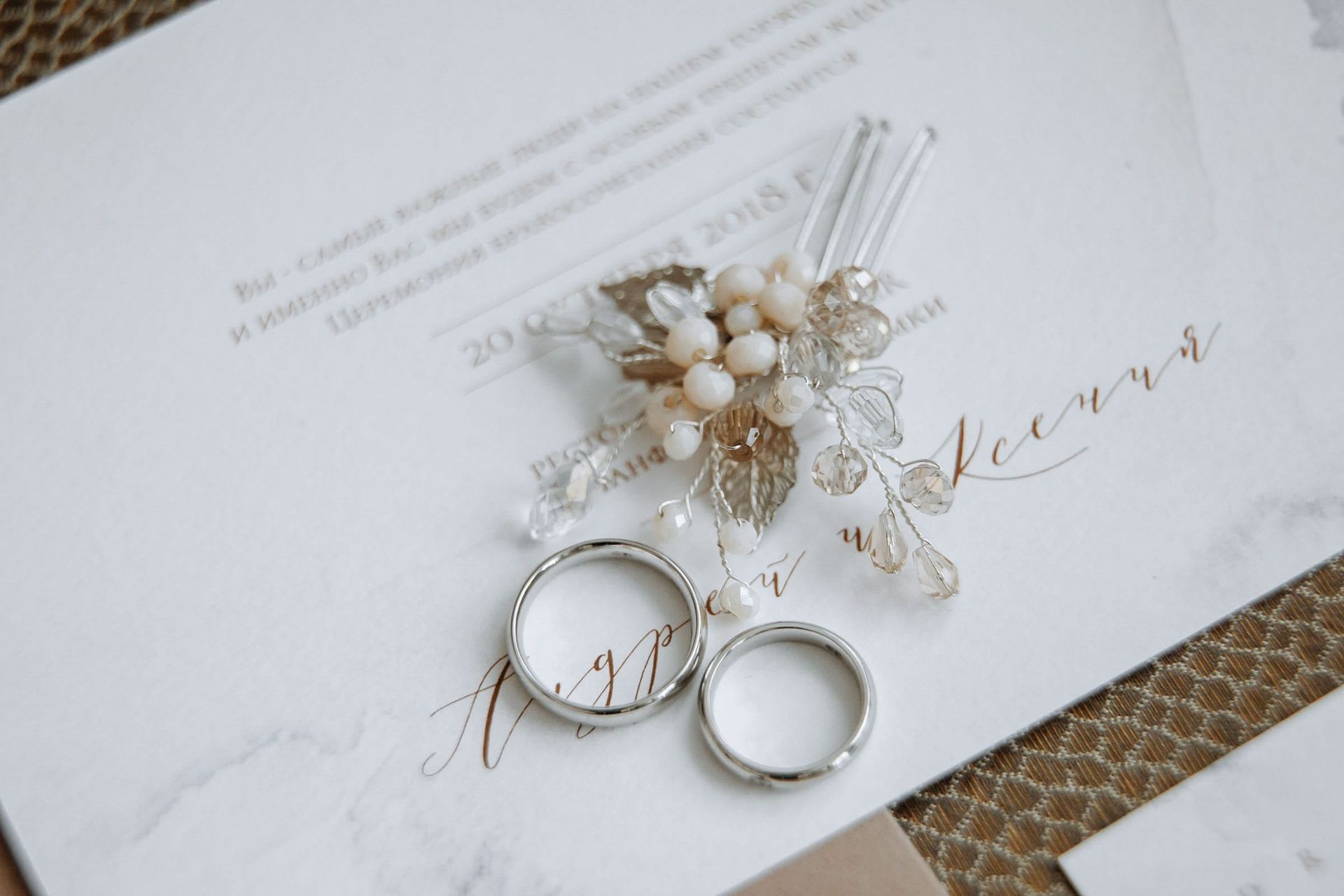 Detailed close-up of wedding rings and brooch by Tanya Bogdan.