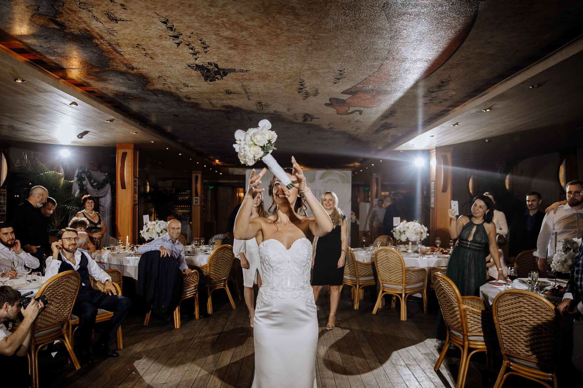 Candid bouquet toss captured by Bude wedding photographer Tanya Bogdan.