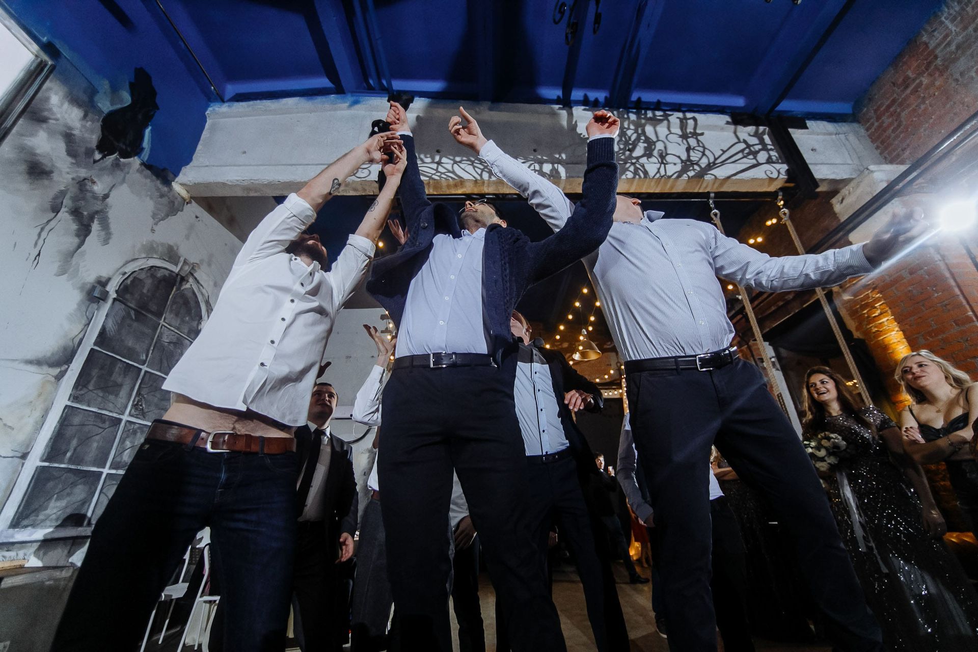Documentary-style photography of the garter toss by Tanya Bogdan.