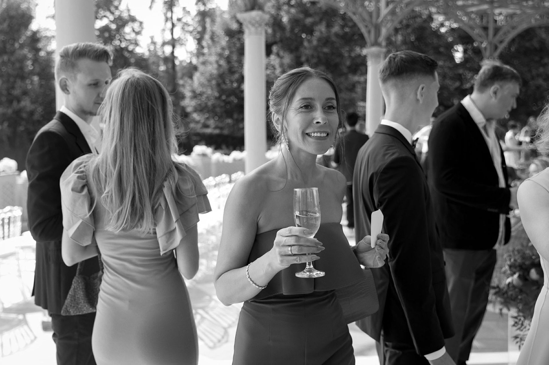 Black and white documentary photo of guest smiling during a destination wedding reception