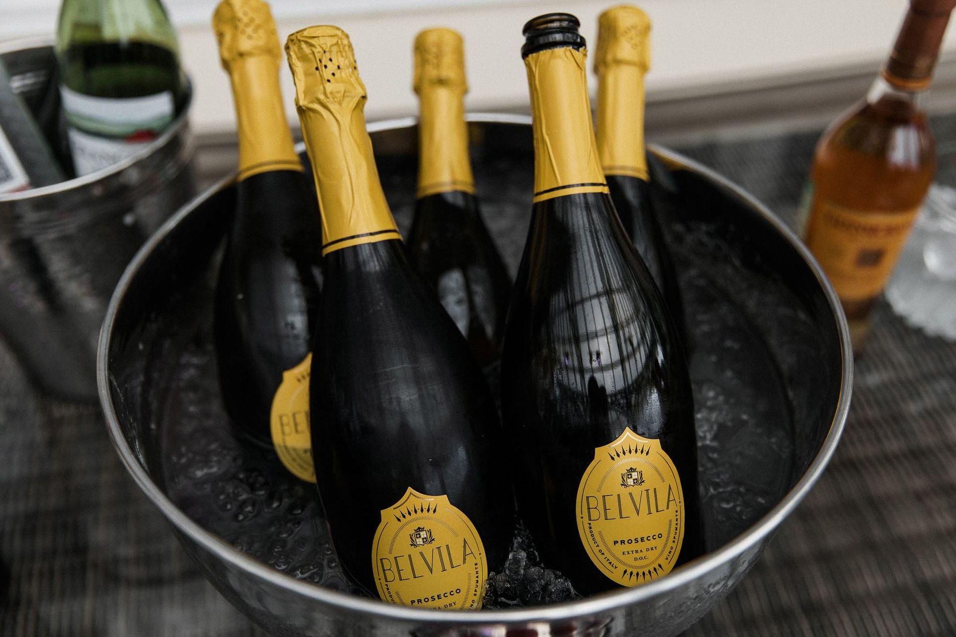 Editorial wedding detail photograph of Belvila prosecco bottles at a destination wedding reception