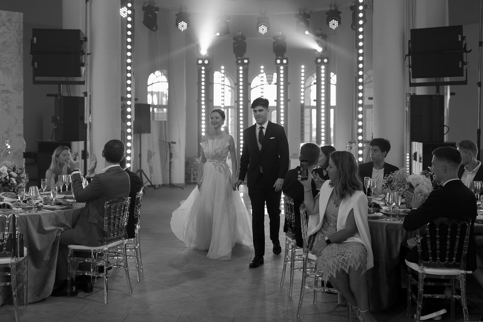 Black and white moment of the bride and groom making their grand entrance at the reception