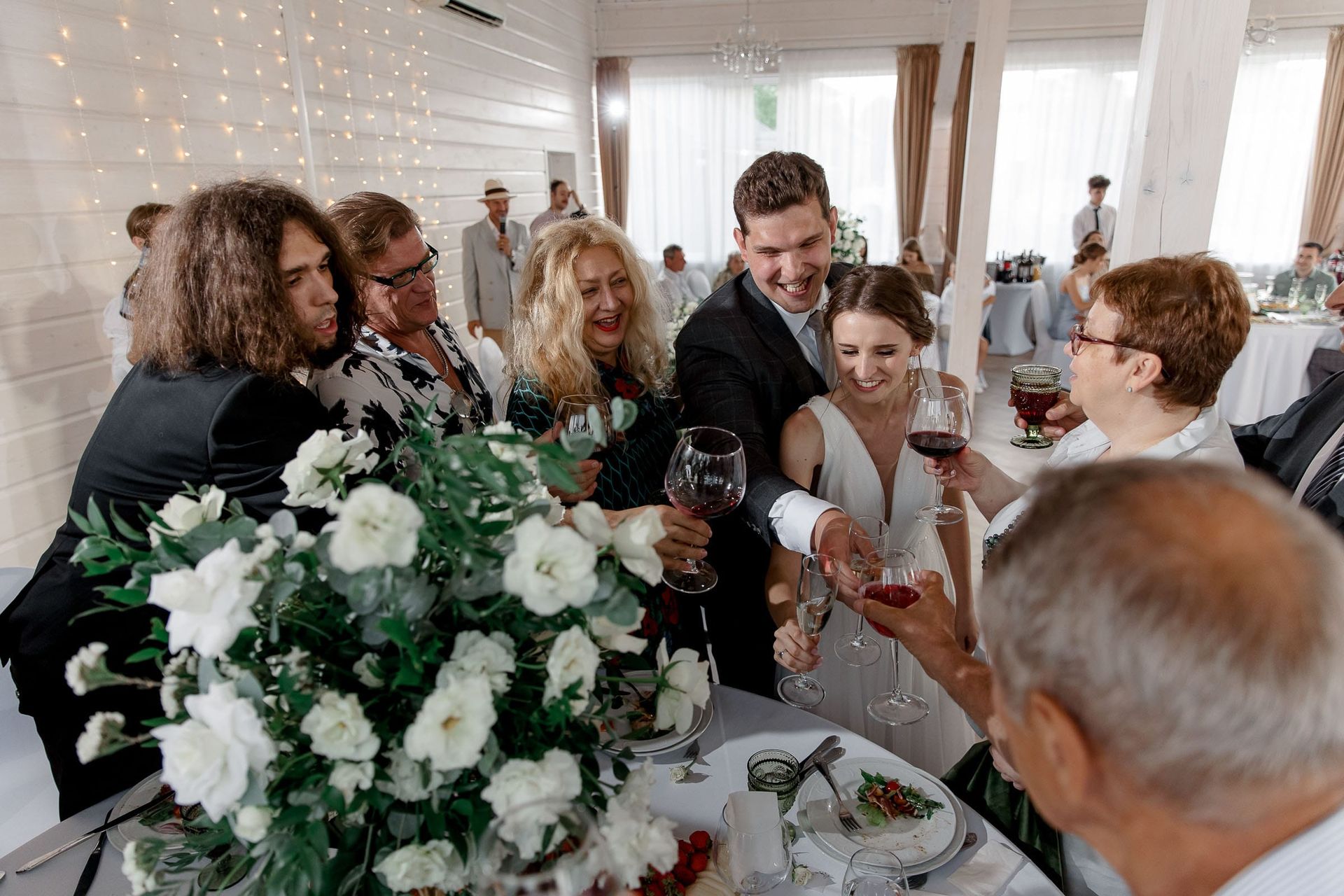 Guests toasting during a riverside wedding reception, captured by a Cornwall wedding photographer.