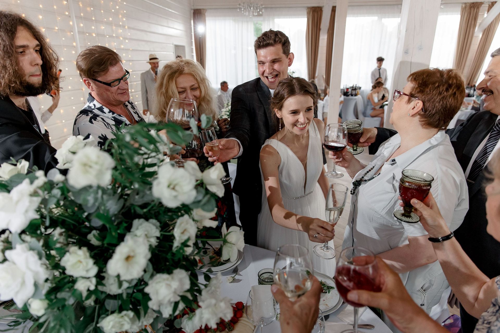 Guests toasting during a riverside wedding reception, captured by a Cornwall wedding photographer.