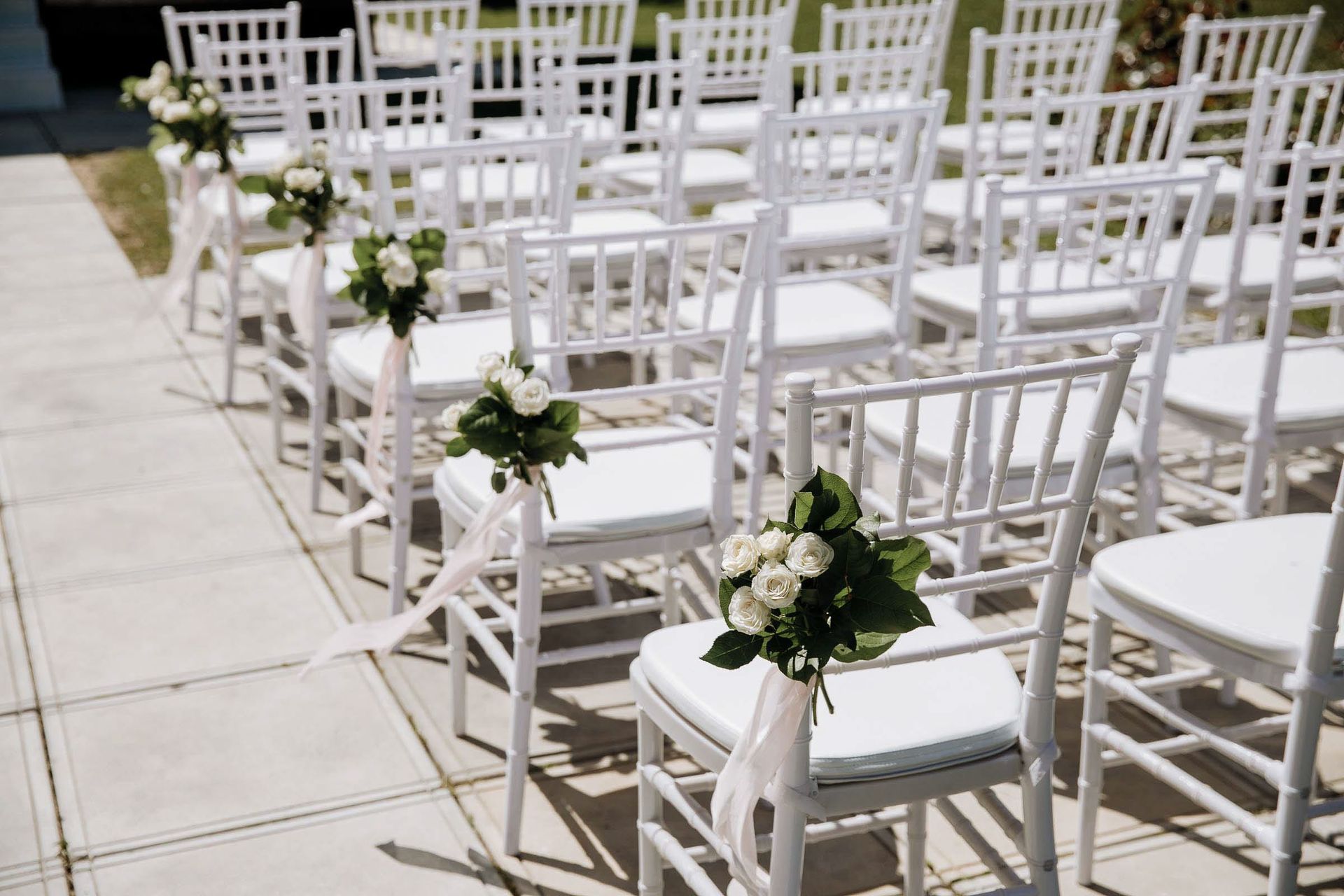 Detailed editorial shot of elegant ceremony floral arrangements on chairs captured by London documentary wedding photographer Tanya Bogdan.