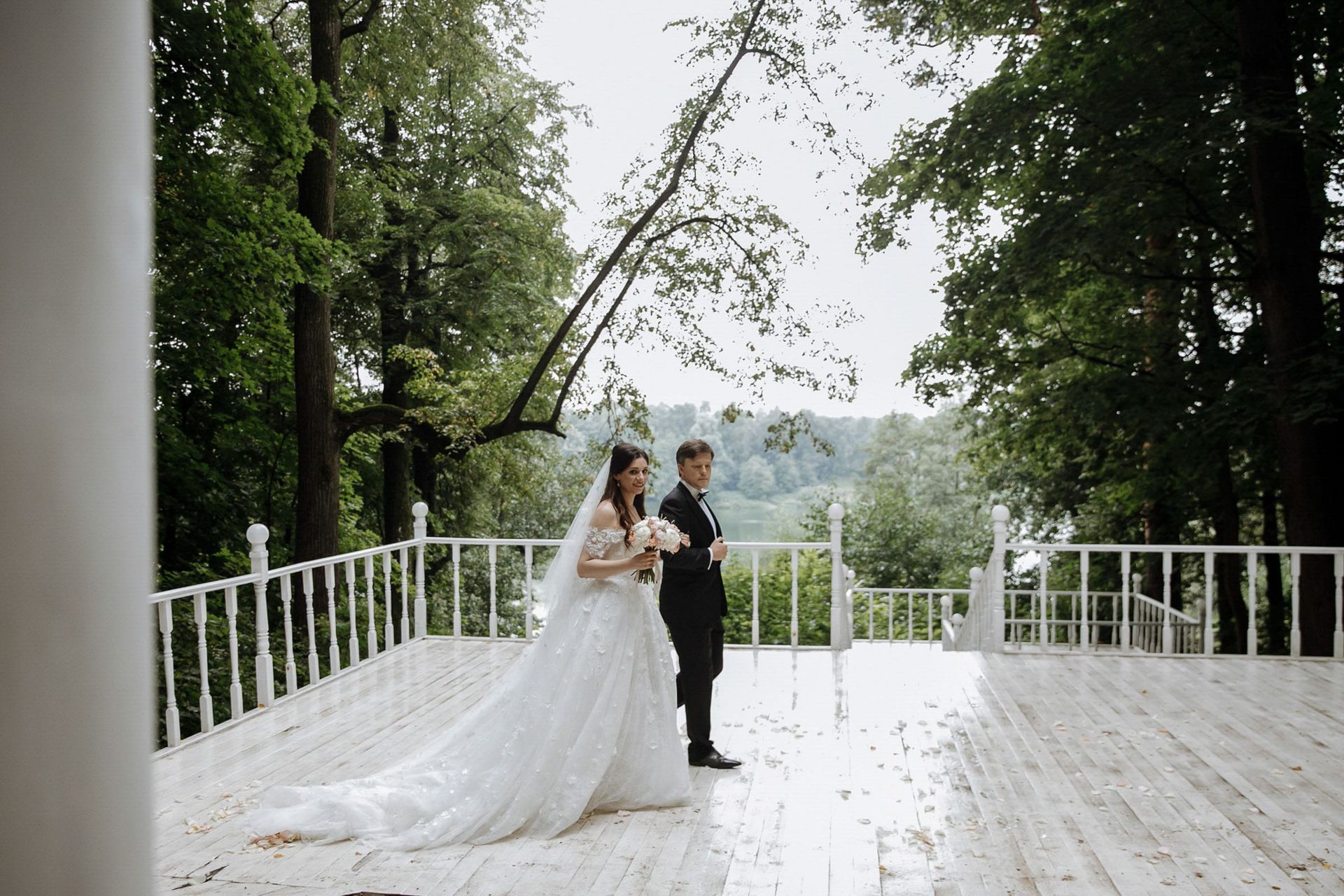 A wide editorial shot of a wedding processional in a grand forest landscape by Tanya Bogdan, serving Devon and the Cotswolds.