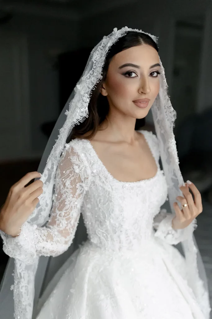 Close-up editorial portrait of a bride wearing a delicate lace veil and long-sleeved wedding gown by London wedding photographer Tanya Bogdan