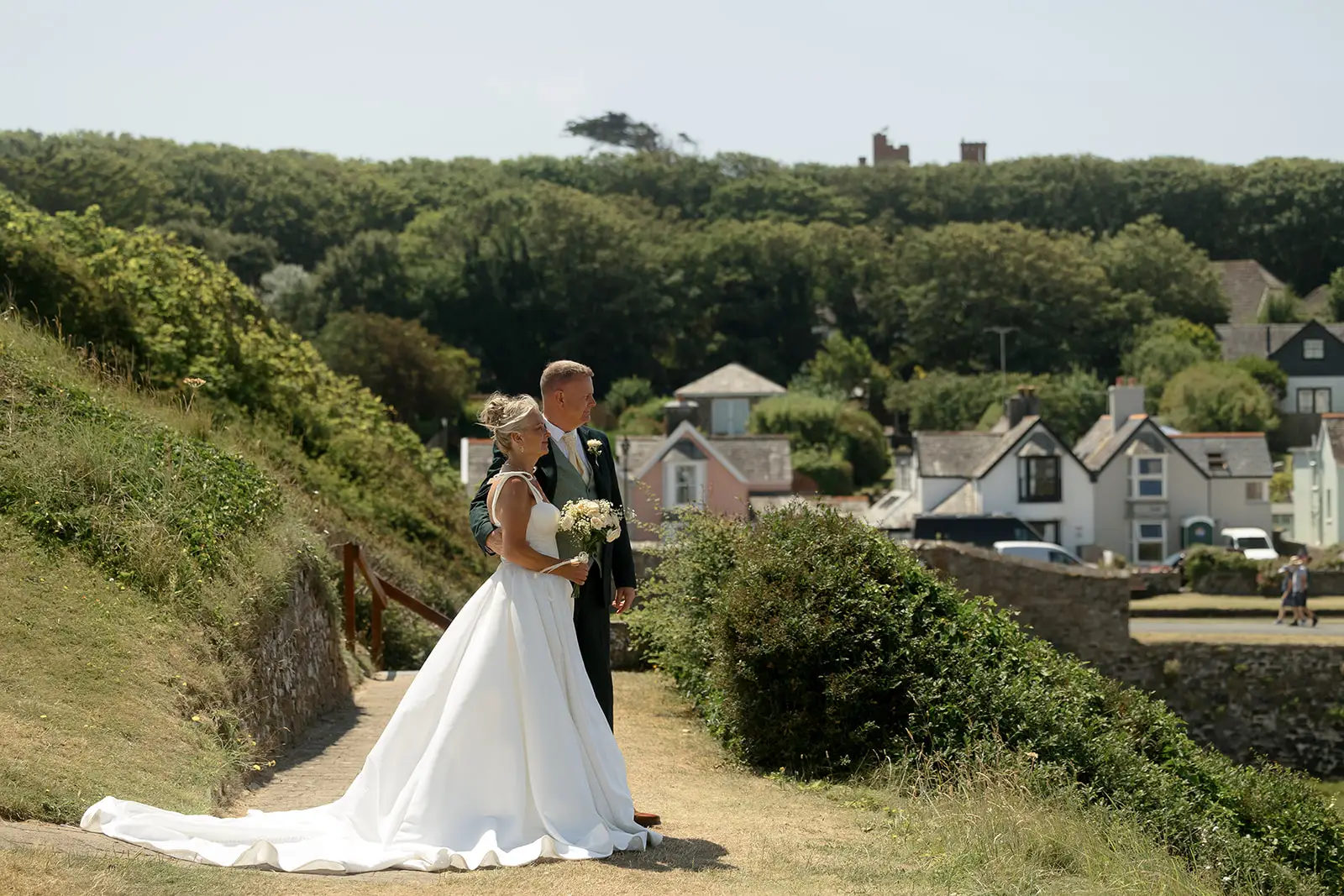 Bride and groom looking out over the scenic landscape of Bude Cornwall, photographed by Tanya Bogdan