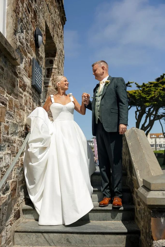 Bride and groom walking together down the steps at Bude Castle, captured by Tanya Bogdan