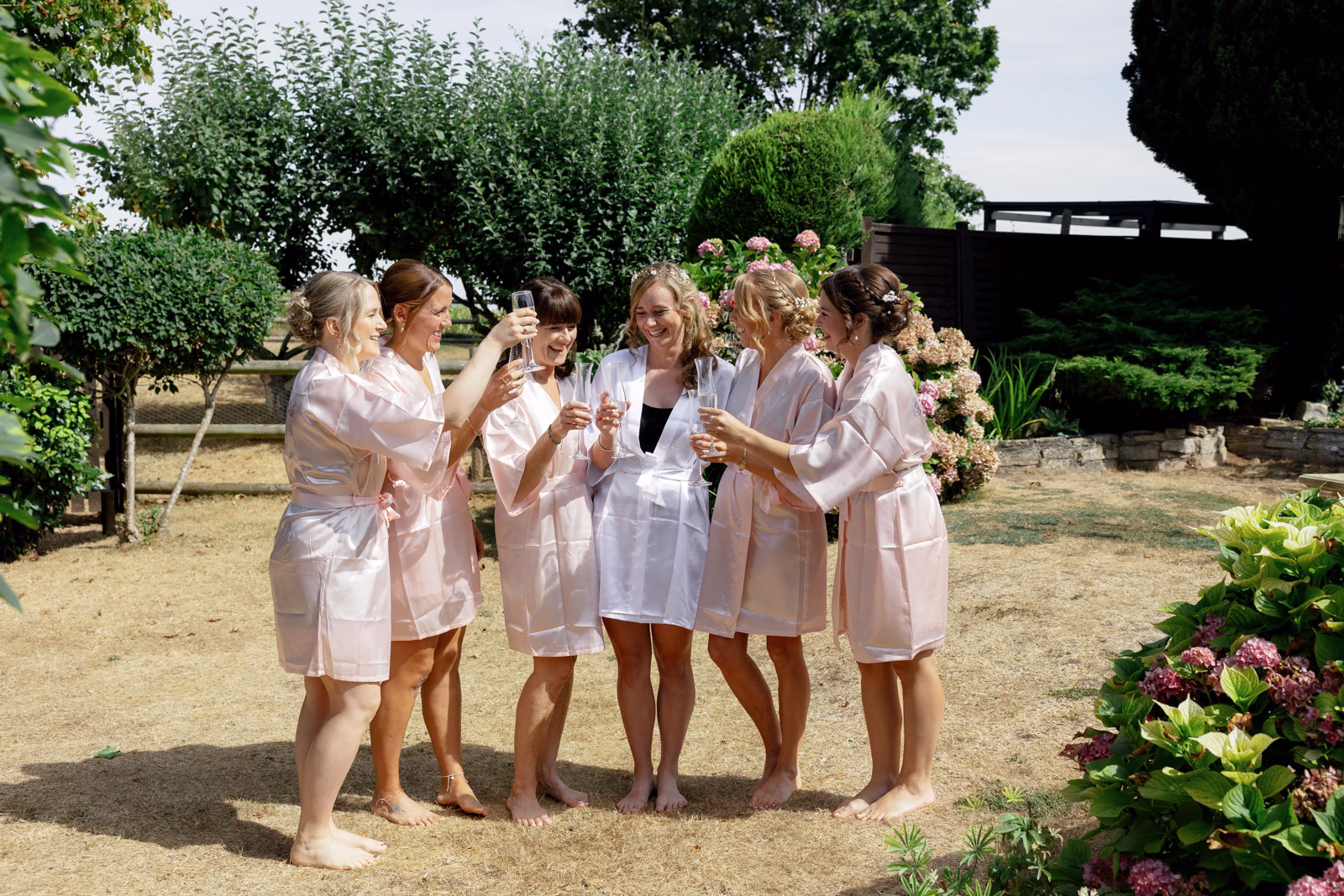 Bridesmaids in robes garden group photo at a family farm wedding in Taunton