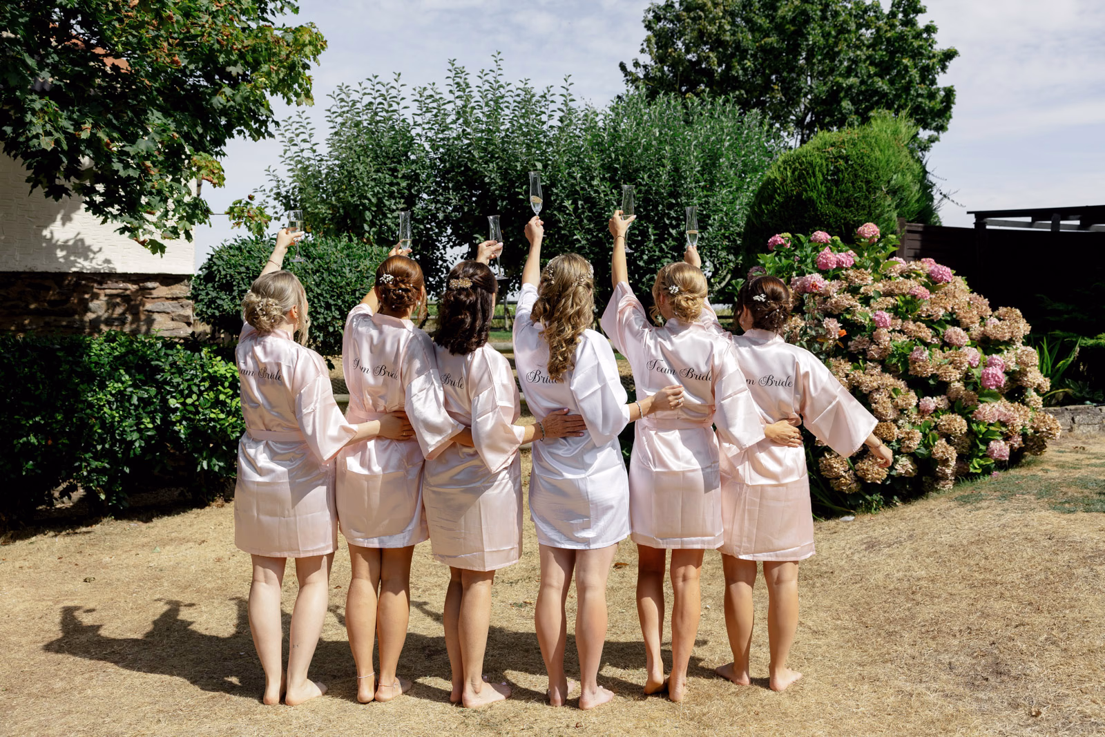 Bridesmaids in robes cheering garden at a family farm wedding in Taunton